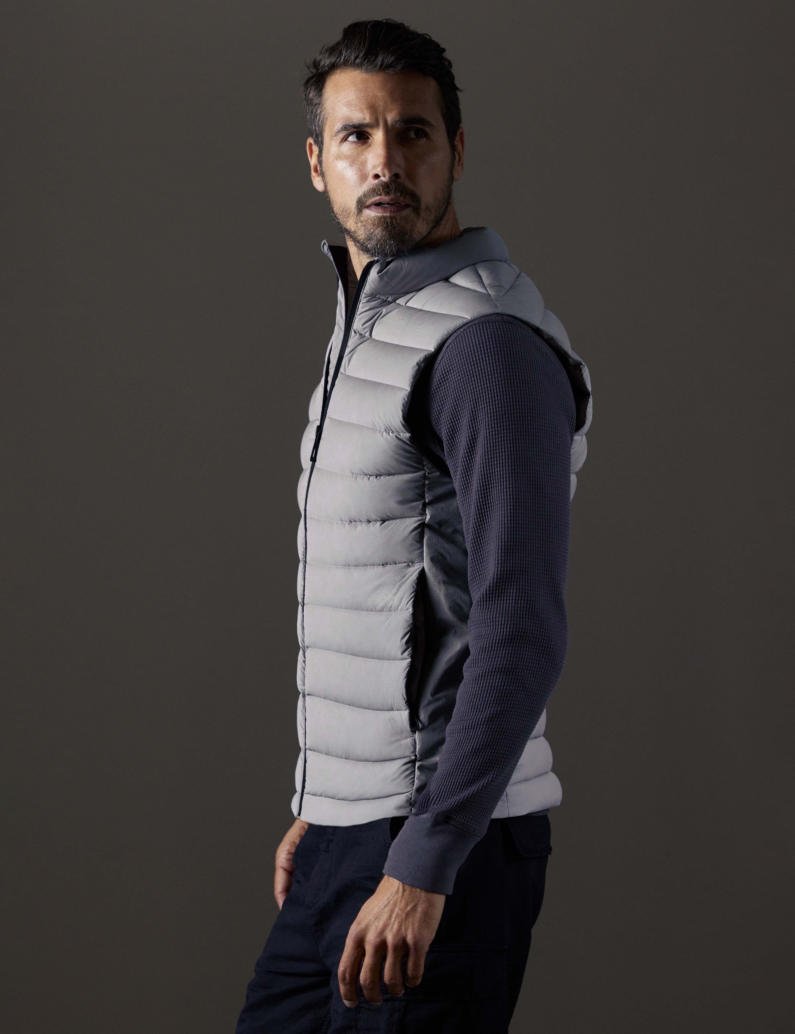 Side profile body view of man wearing Launch Vest in Sky Grey from AETHER Apparel.