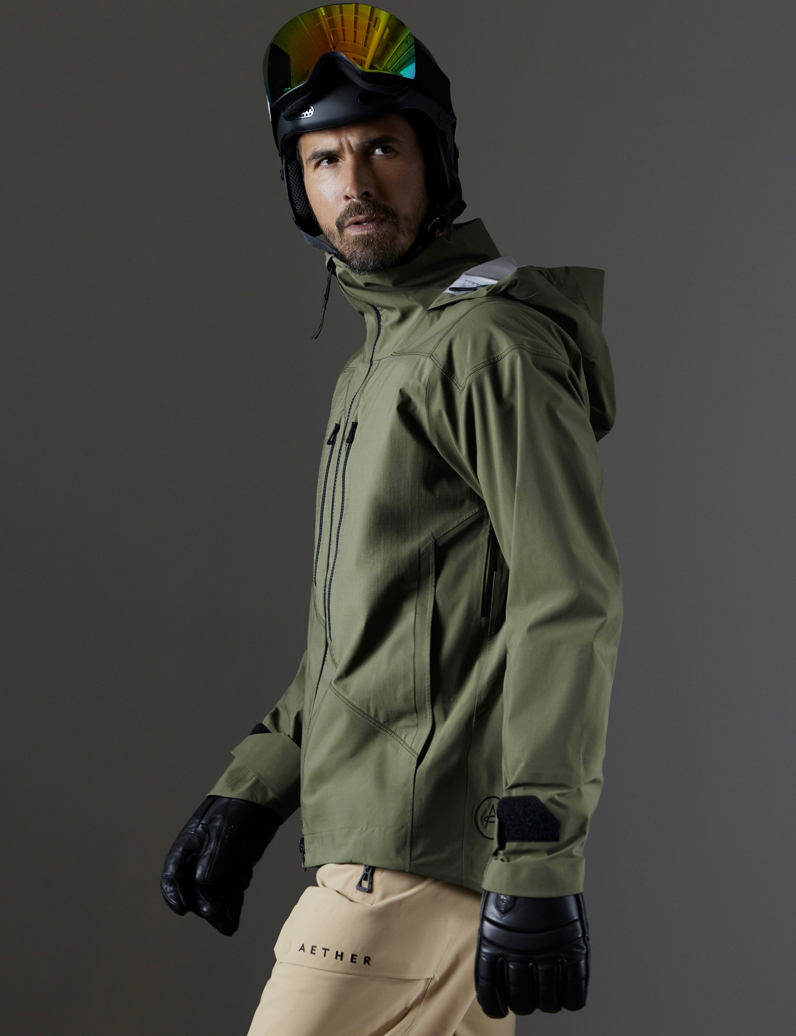 Side profile body view of man wearing Maverick Snow-Shell Jacket in Fern Green from AETHER Apparel.