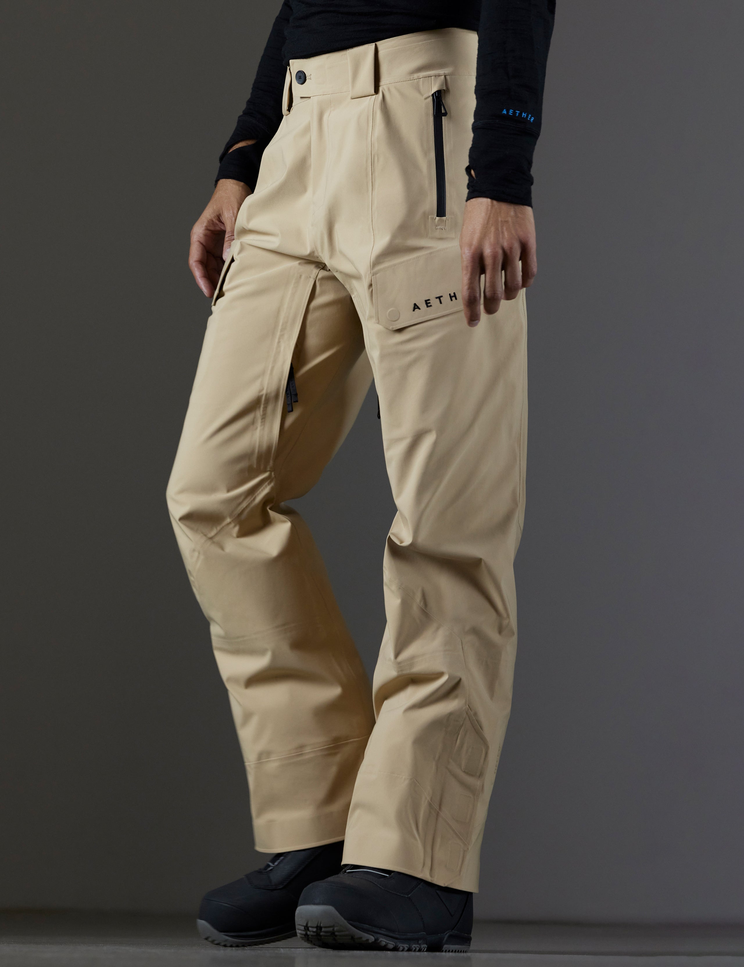 Front 3/4 lower body view of man wearing Maverick Snow-Shell Pant in Desert Tan from AETHER Apparel.