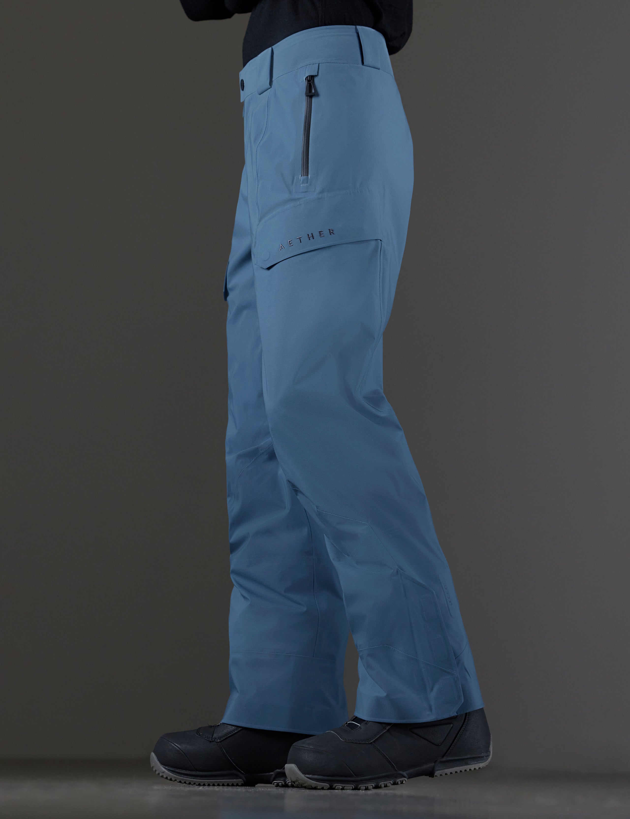 Side profile lower body view of man wearing Maverick Snow-Shell Pant in Portal Blue from AETHER Apparel.