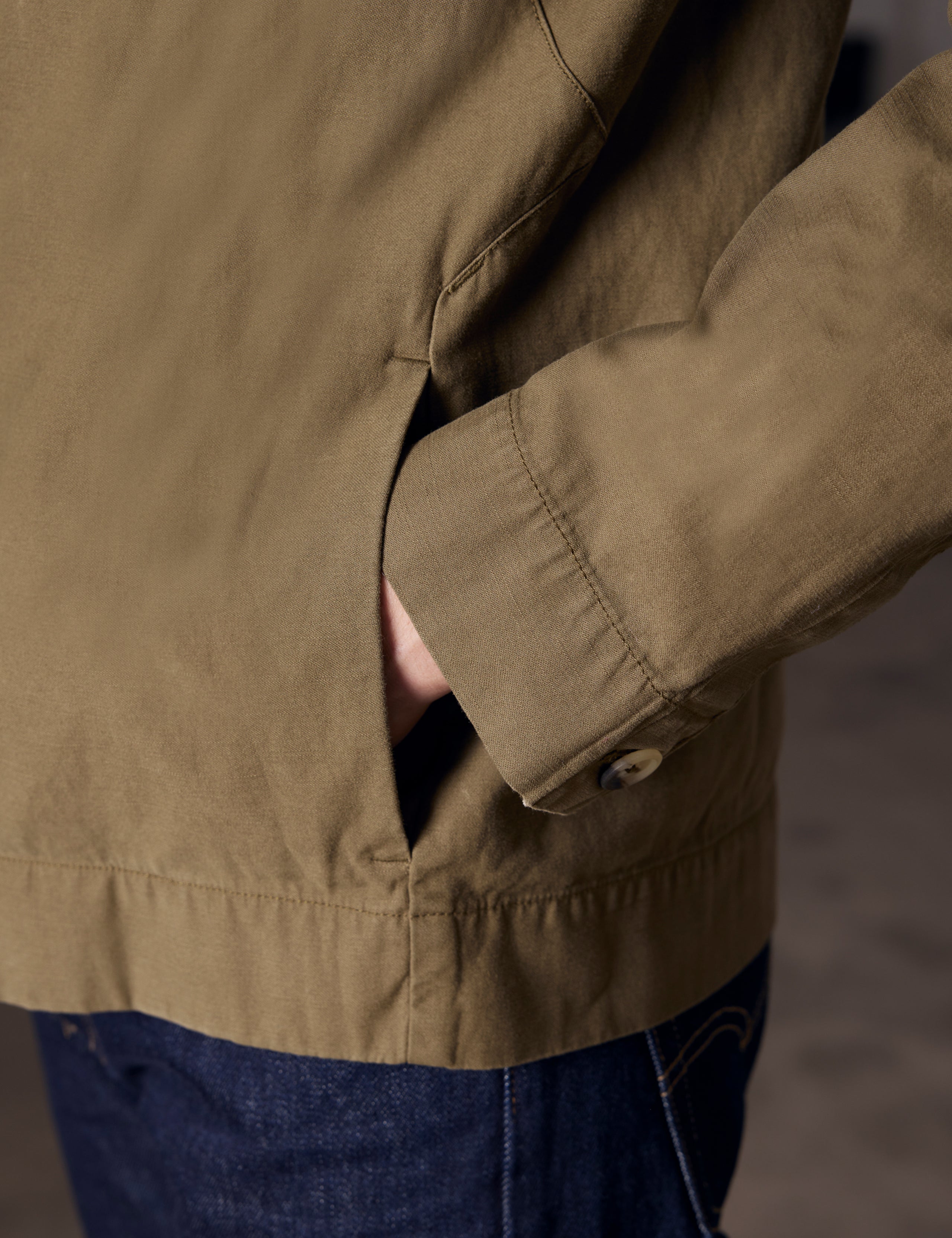 Closeup detaied view of man with hand in pocket of Mesa Jacket in Command Green from AETHER Apparel.