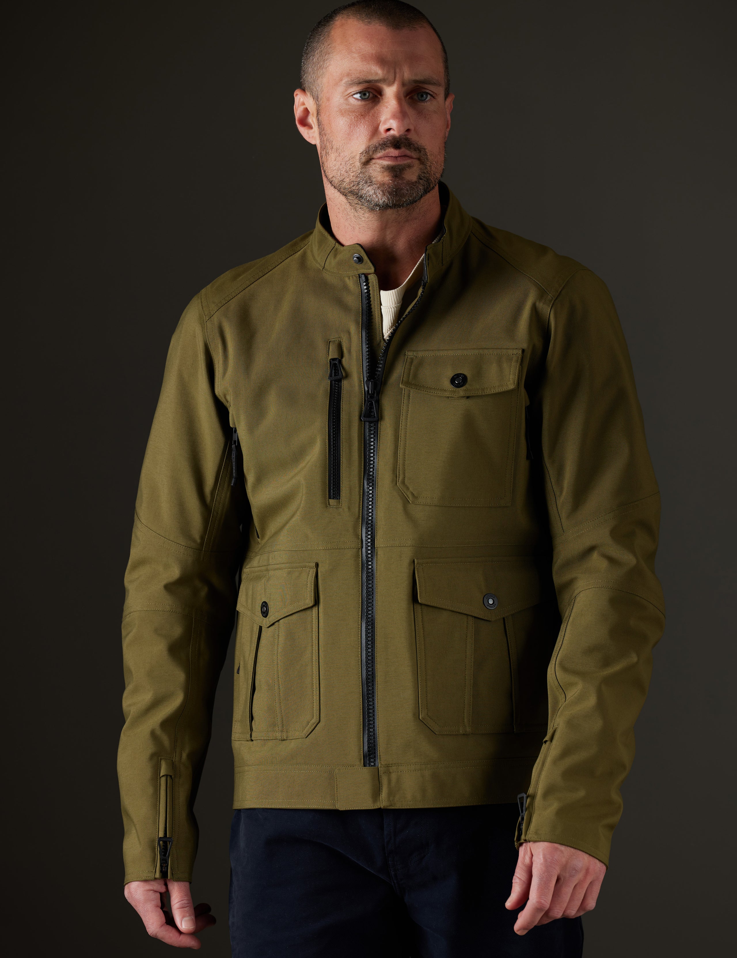 Front body view of man wearing Mulholland Motorcycle Jacket in Command Green from AETHER Apparel.