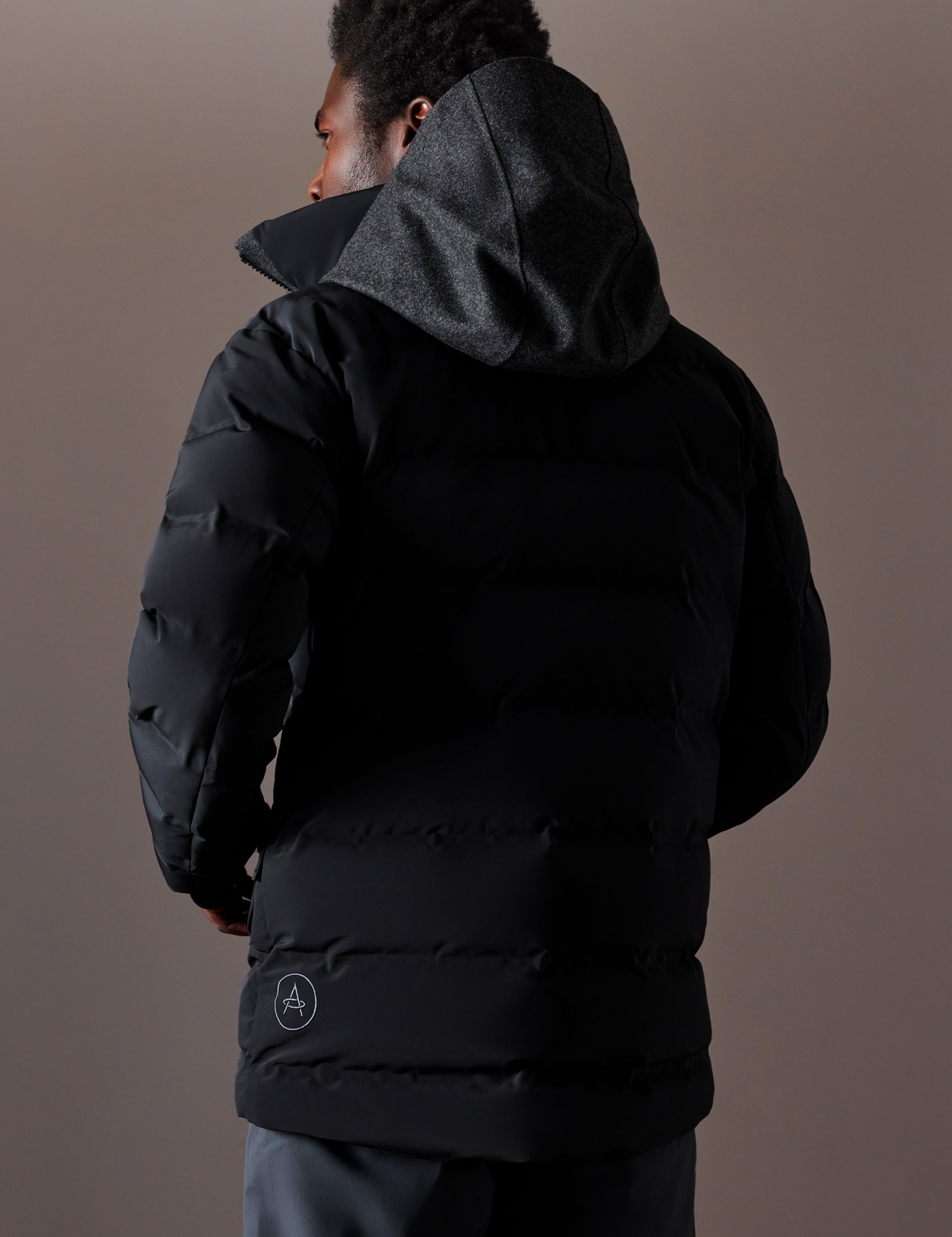 Rear 3/4 body view of man wearing Nordic Jacket in Jet Black from AETHER Apparel.