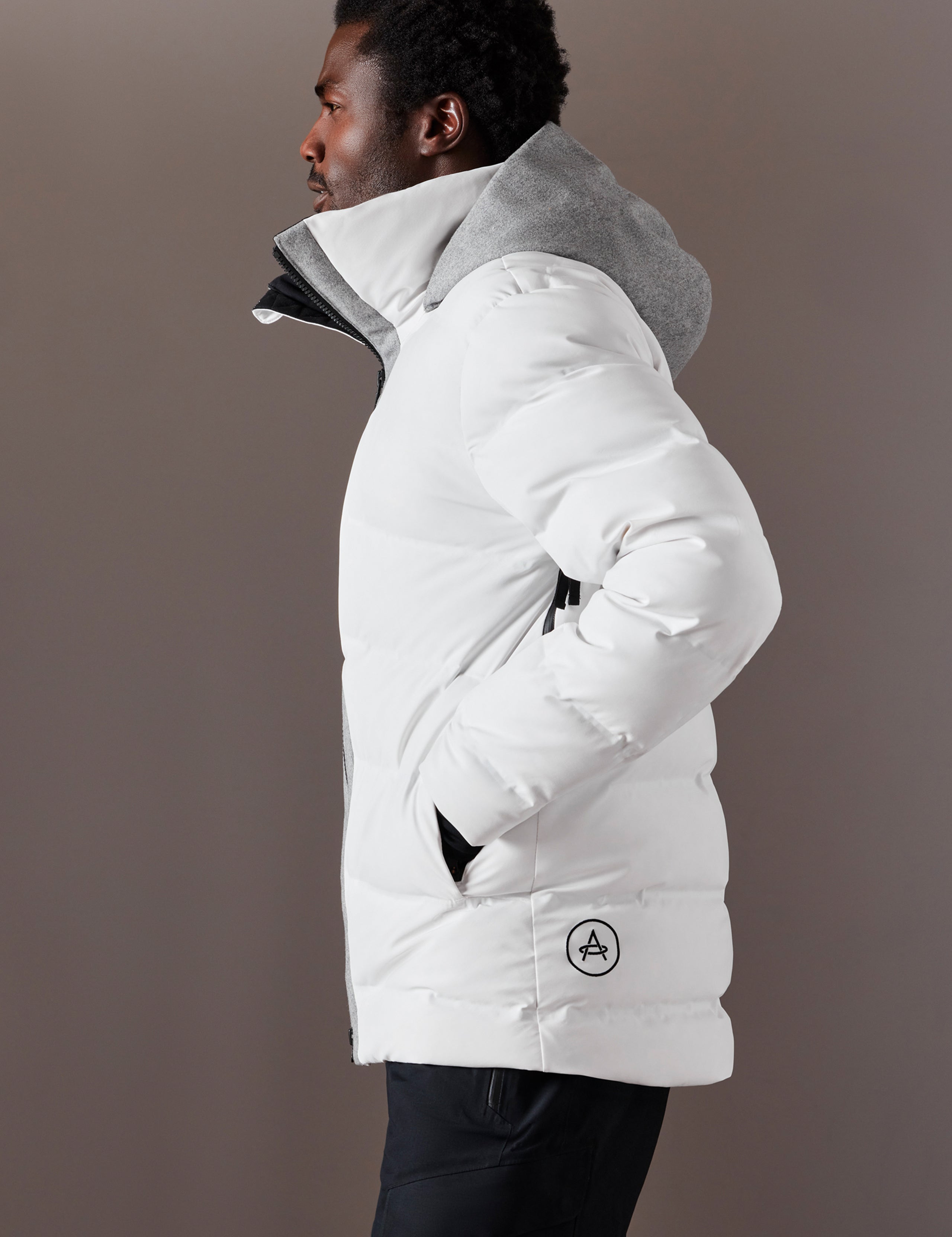 Side profile body view of man wearing Nordic Jacket in White from AETHER Apparel.