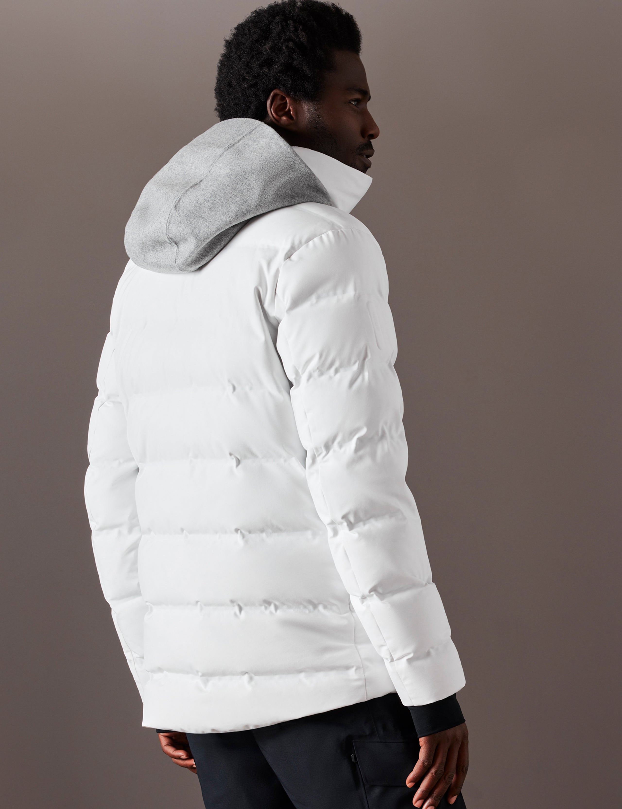 Rear 3/4 body view of man wearing Nordic Jacket in White from AETHER Apparel.