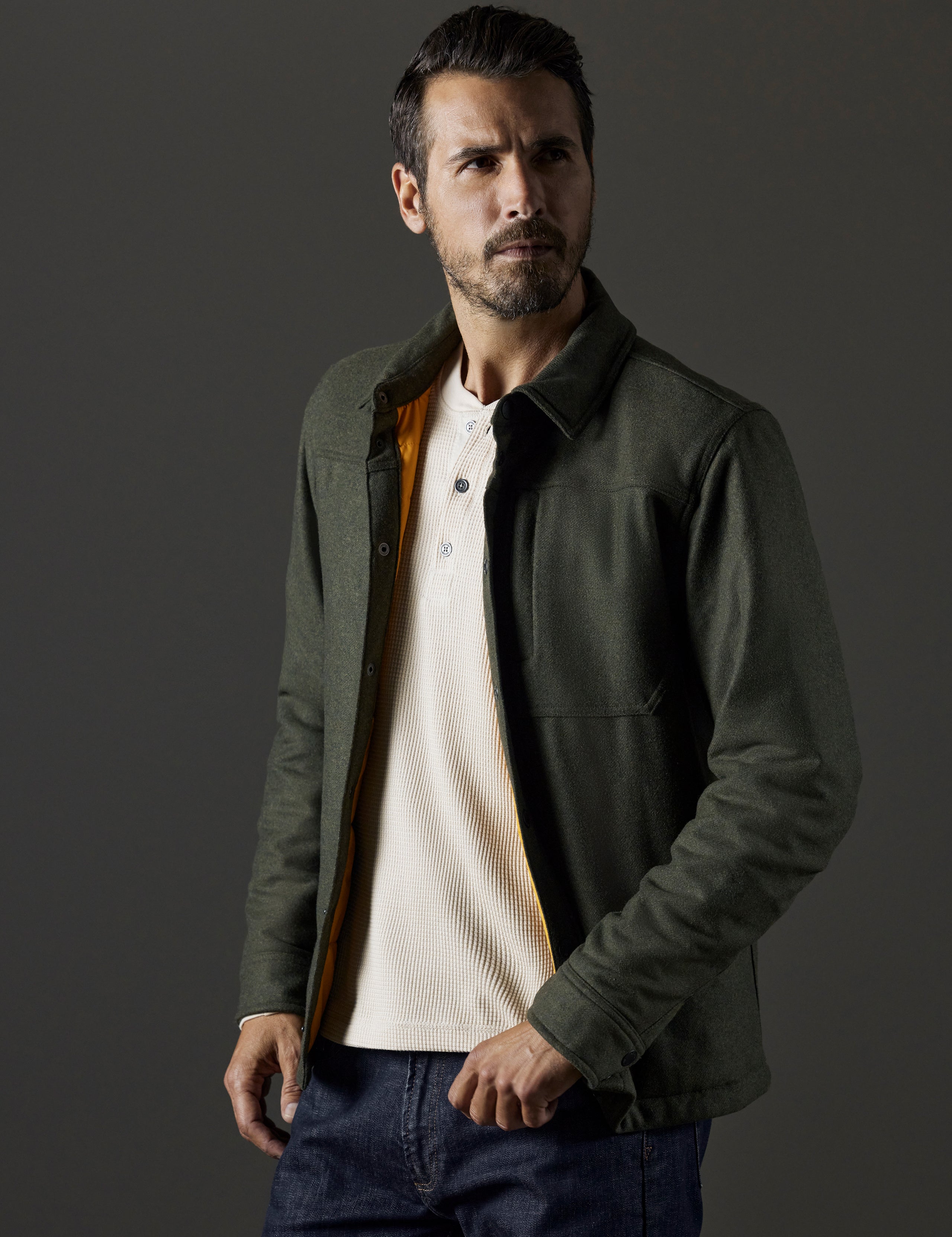 Front 3/4 body view of man wearing unbuttoned Nova Insulated Button-Down in Command Green from AETHER Apparel.