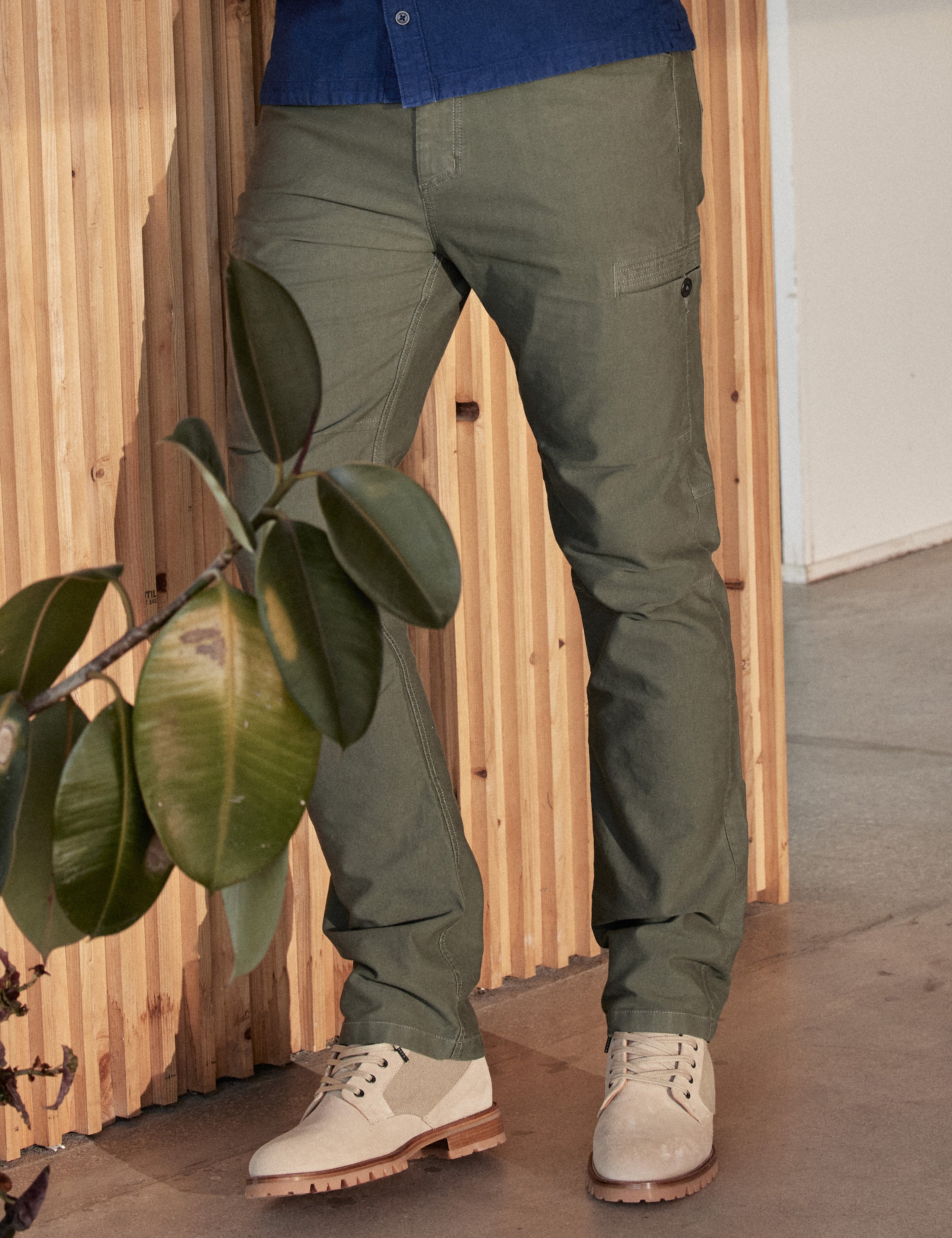Lifestyle image of man leaning against wall wearing Ojai City Boot in Natural suede and canvas from AETHER Apparel.