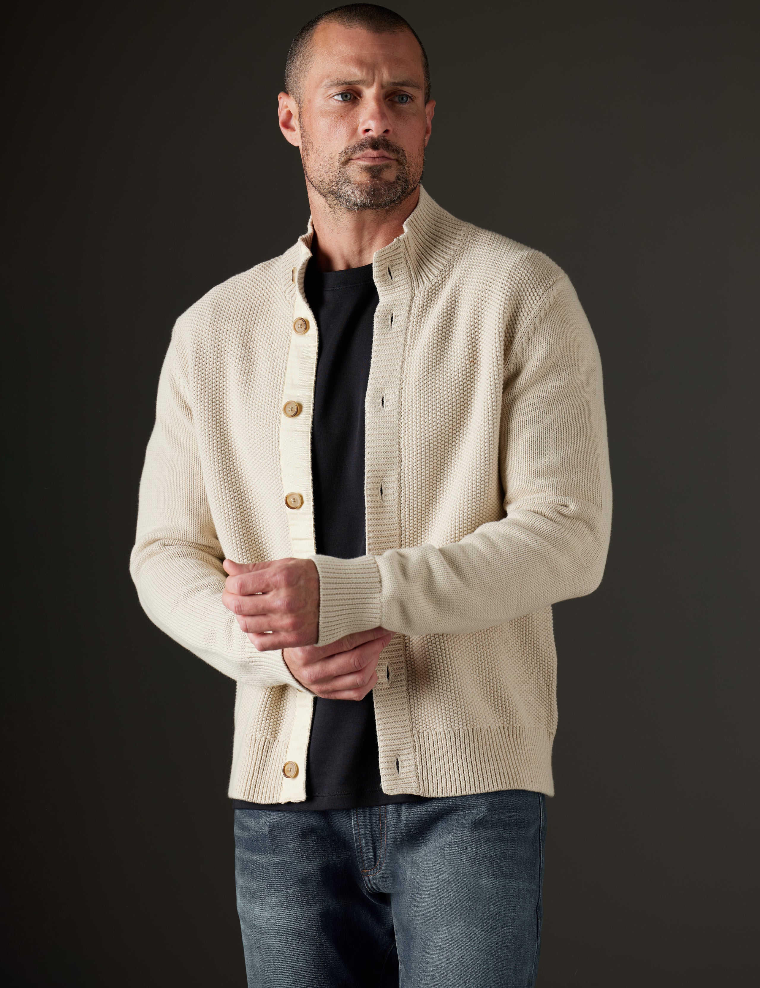 Front 3/4 body view of man wearing unbutoned Oliver Cotton Button-Up Sweater in Bone white from AETHER Apparel.