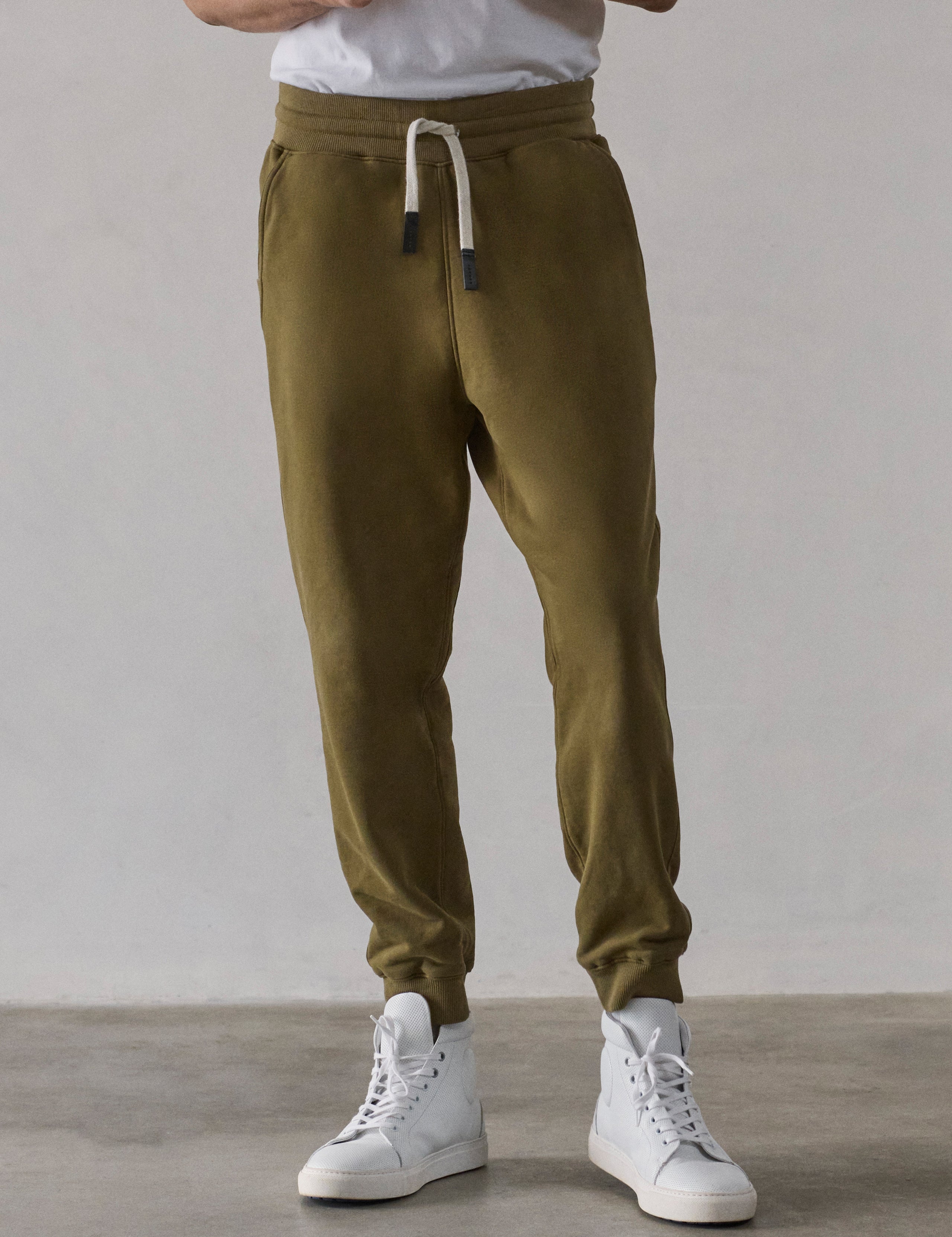 Front lower-body view of man wearing Osa Cuffed Sweatpant in Command Green from AETHER Apparel.