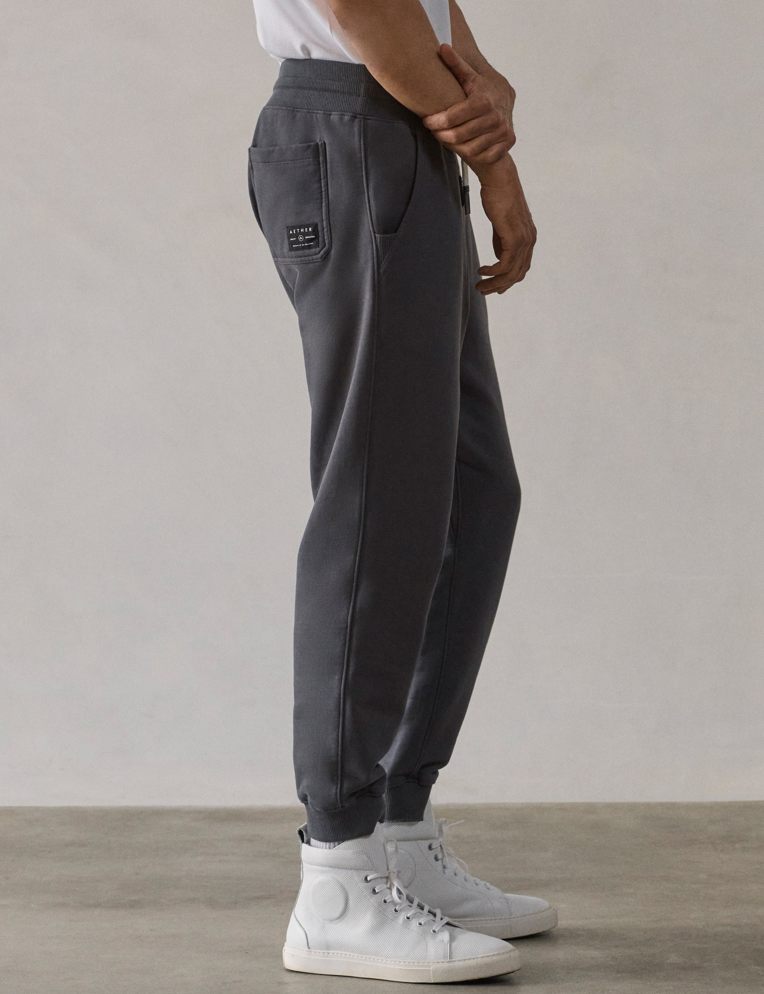 Right side profile lower-body view of man wearing Osa Cuffed Sweatpant in Graphite grey from AETHER Apparel.