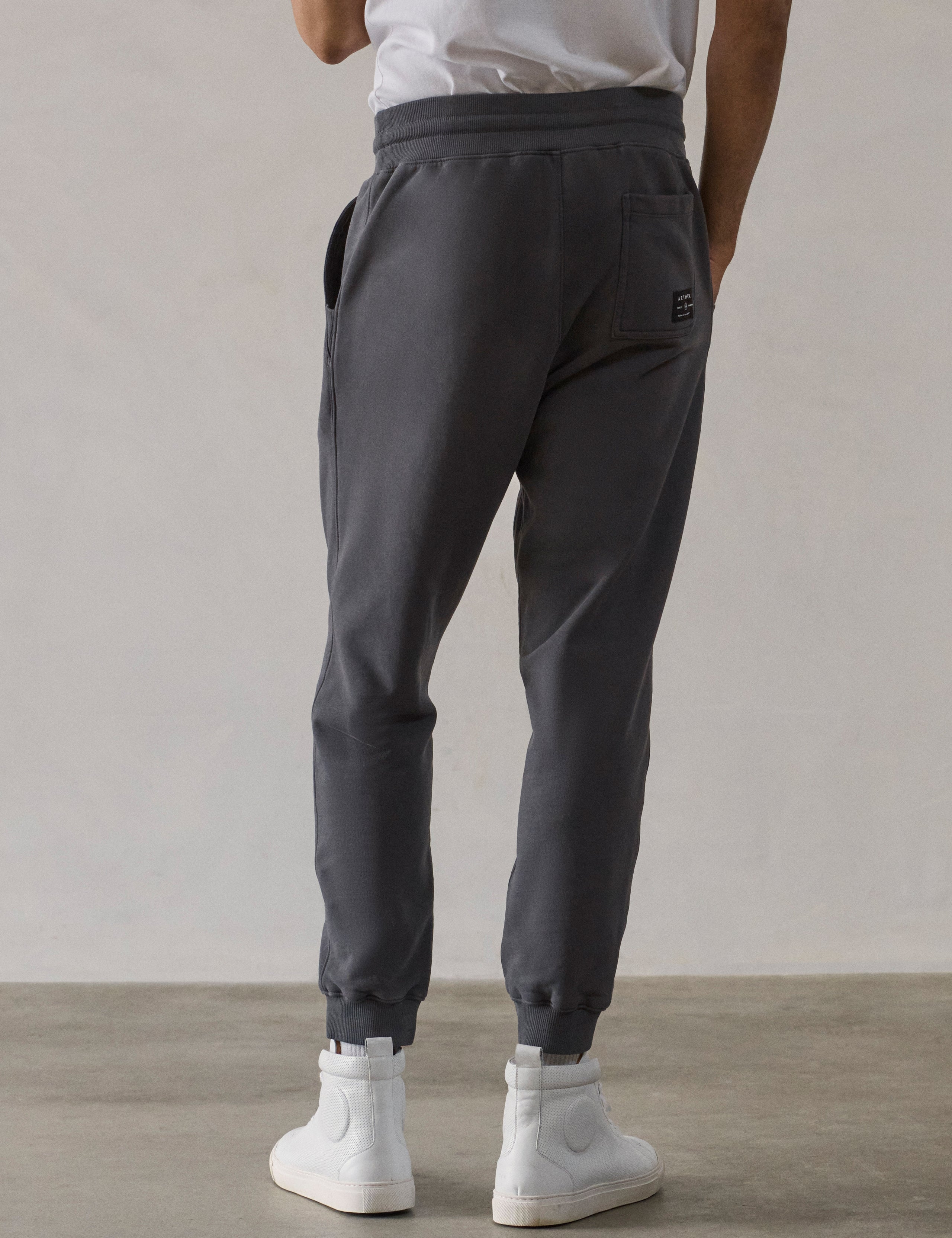 Rear lower-body view of man wearing Osa Cuffed Sweatpant in Graphite grey from AETHER Apparel.