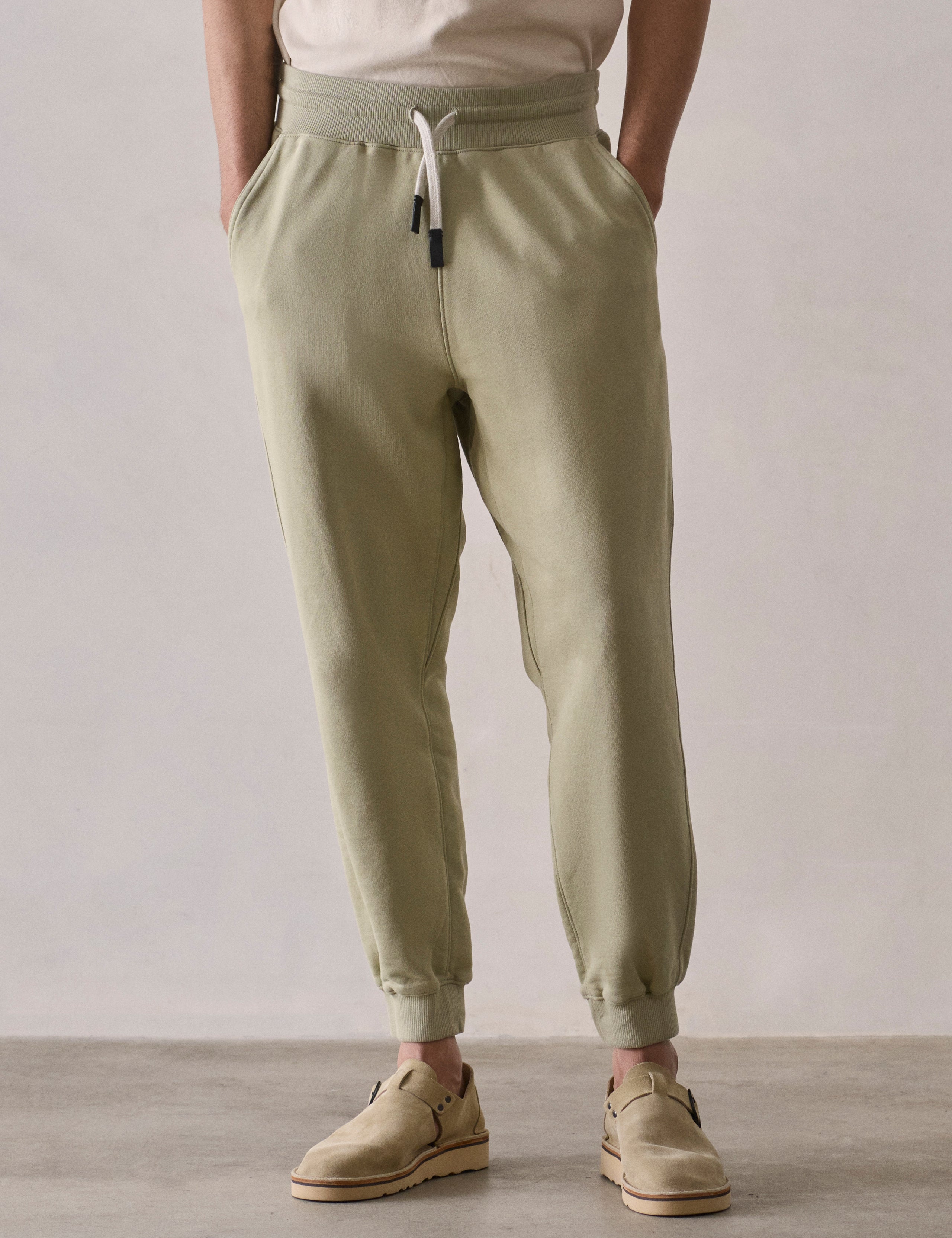 Front lower body view of man wearing Osa Cuffed Sweatpant in Sage Green from AETHER Apparel.