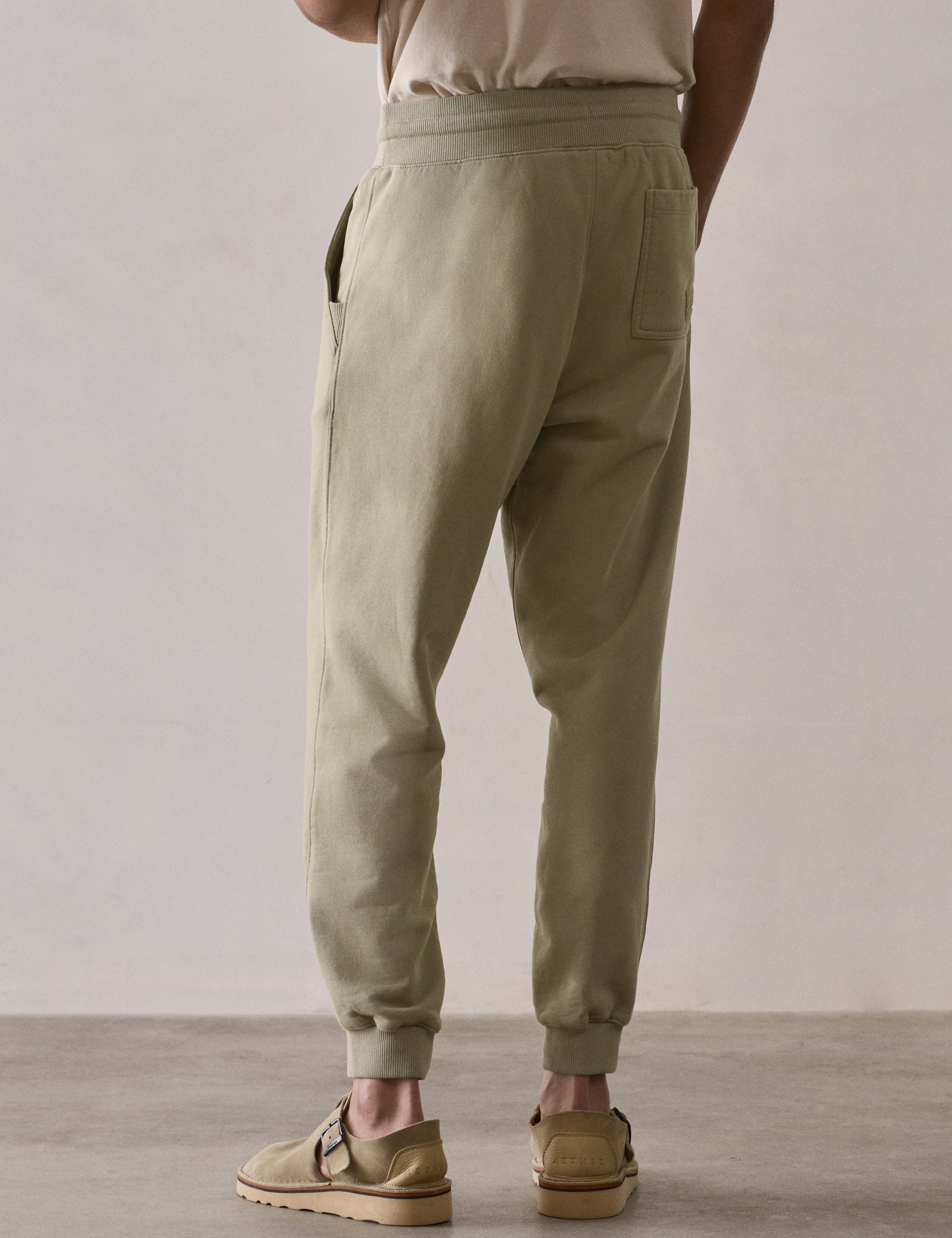 Rear lower body view of man wearing Osa Cuffed Sweatpant in Sage Green from AETHER Apparel.