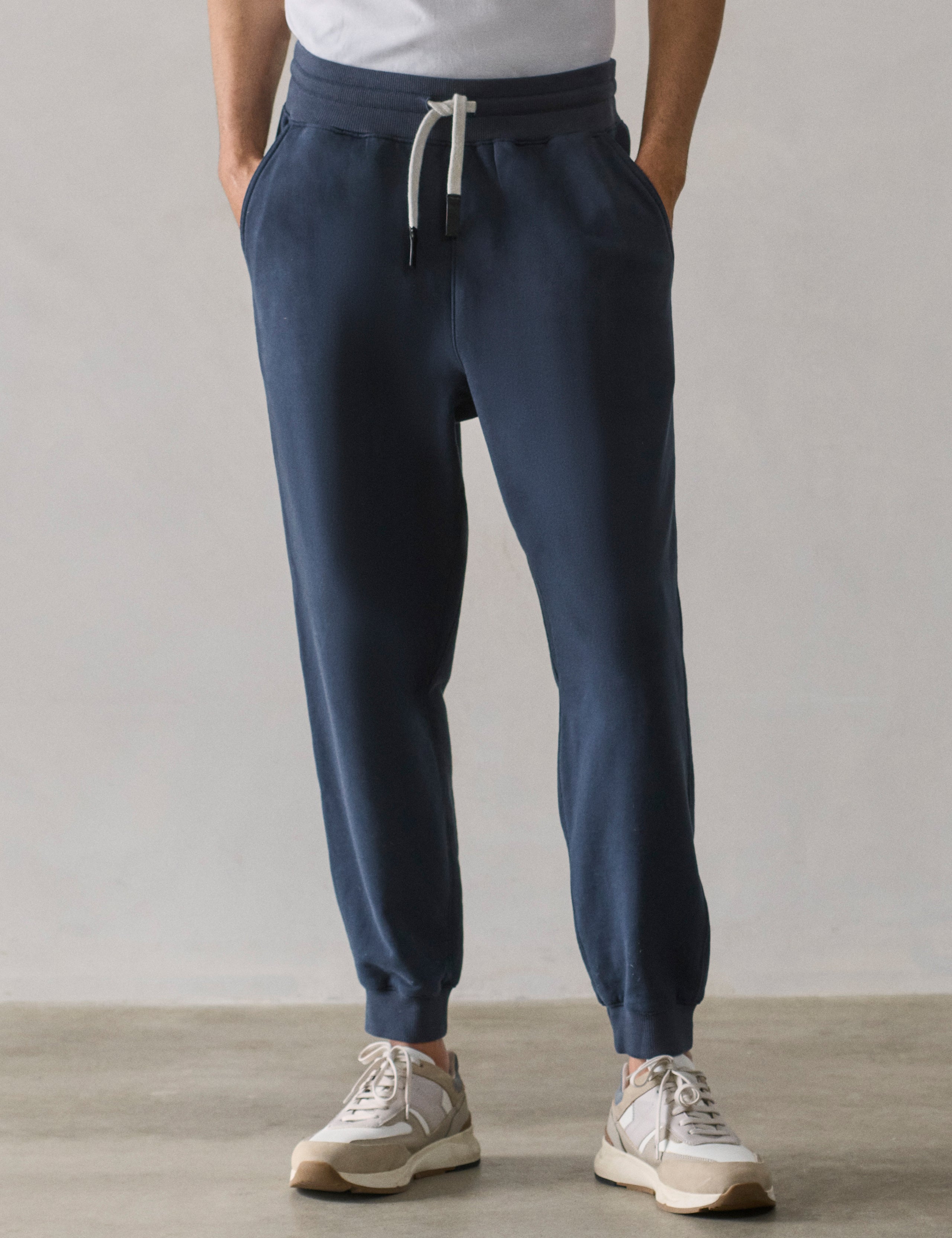 Front lower body view of man wearing Osa Cuffed Sweatpant in Total Eclipse dark blue from AETHER Apparel.