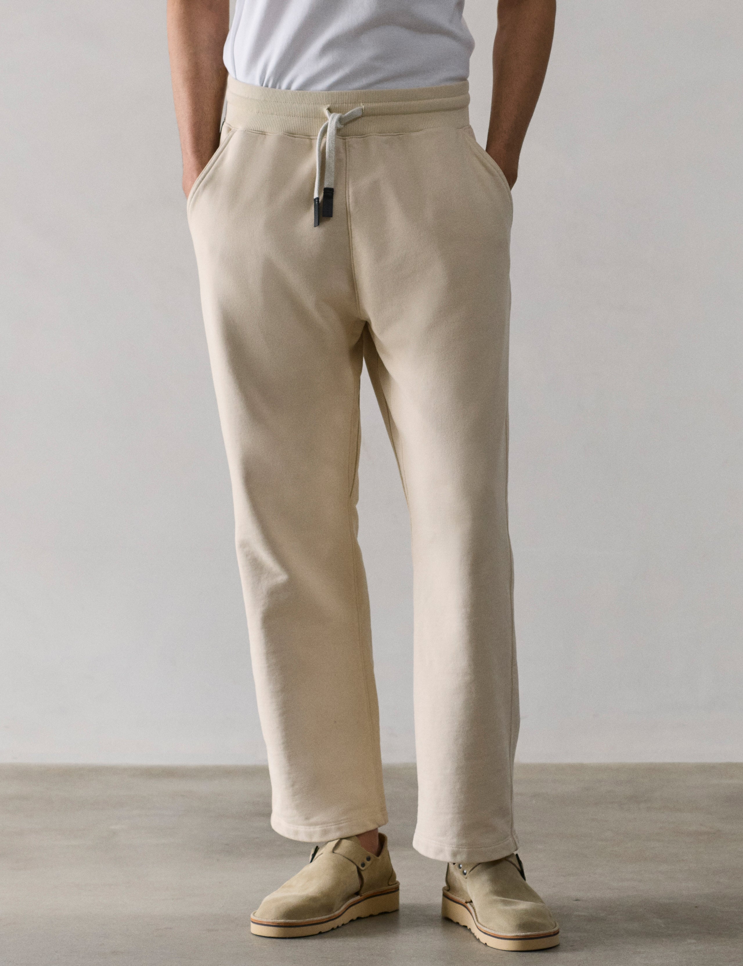 Front lower body view of man wearing Osa Easy-Fit Sweatpant in Bone white from AETHER Apparel.