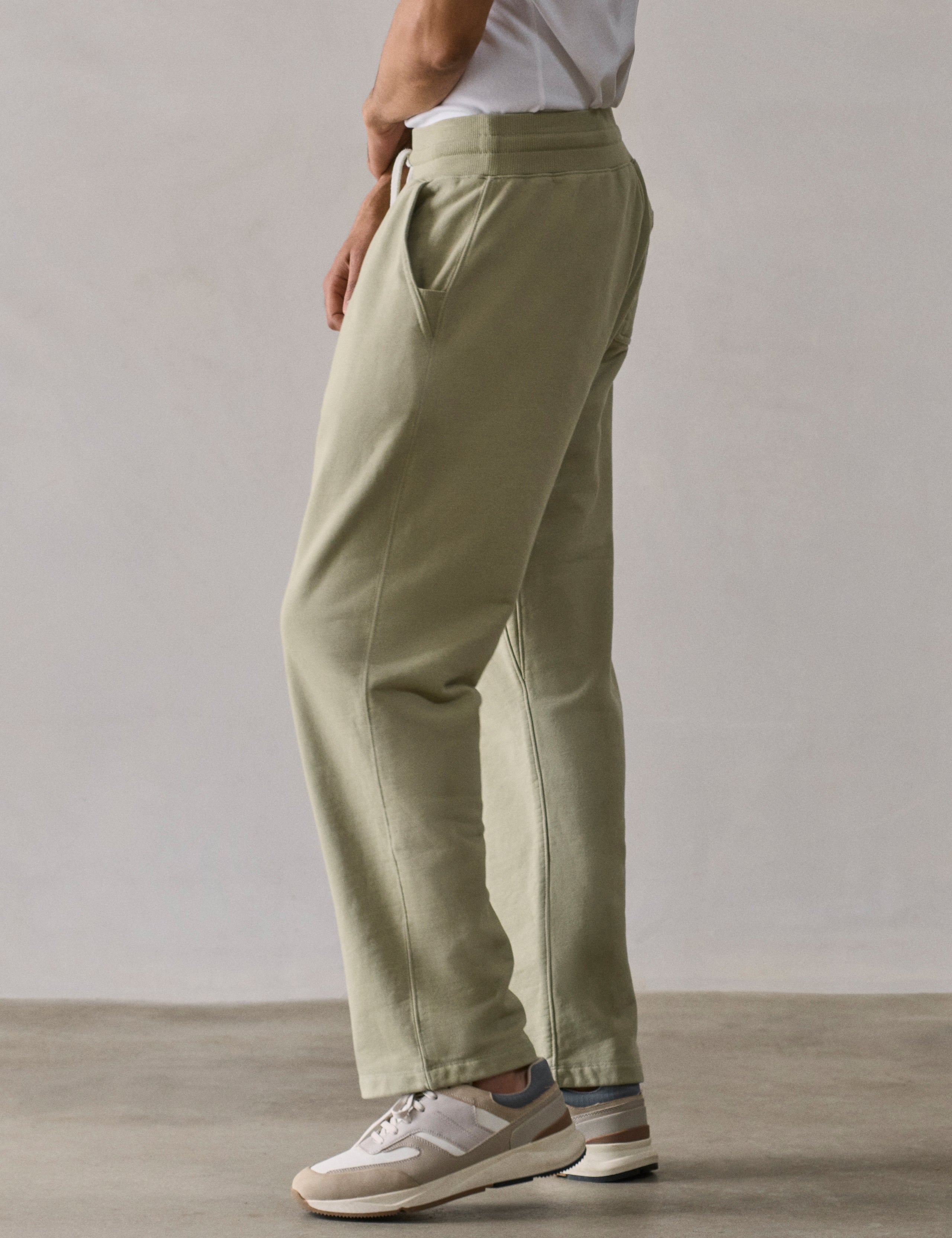 Rear 3/4 lower body view of man wearing Osa Easy-Fit Sweatpant in Sage Green from AETHER Apparel.