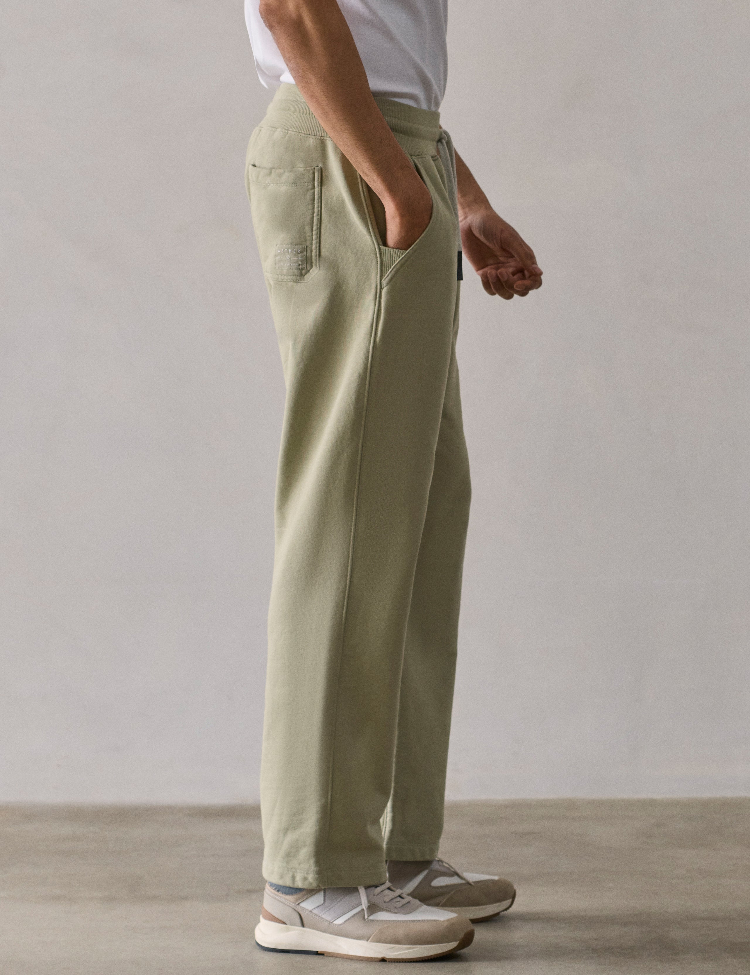 Right side lower body profile view of man wearing Osa Easy-Fit Sweatpant in Sage Green from AETHER Apparel.