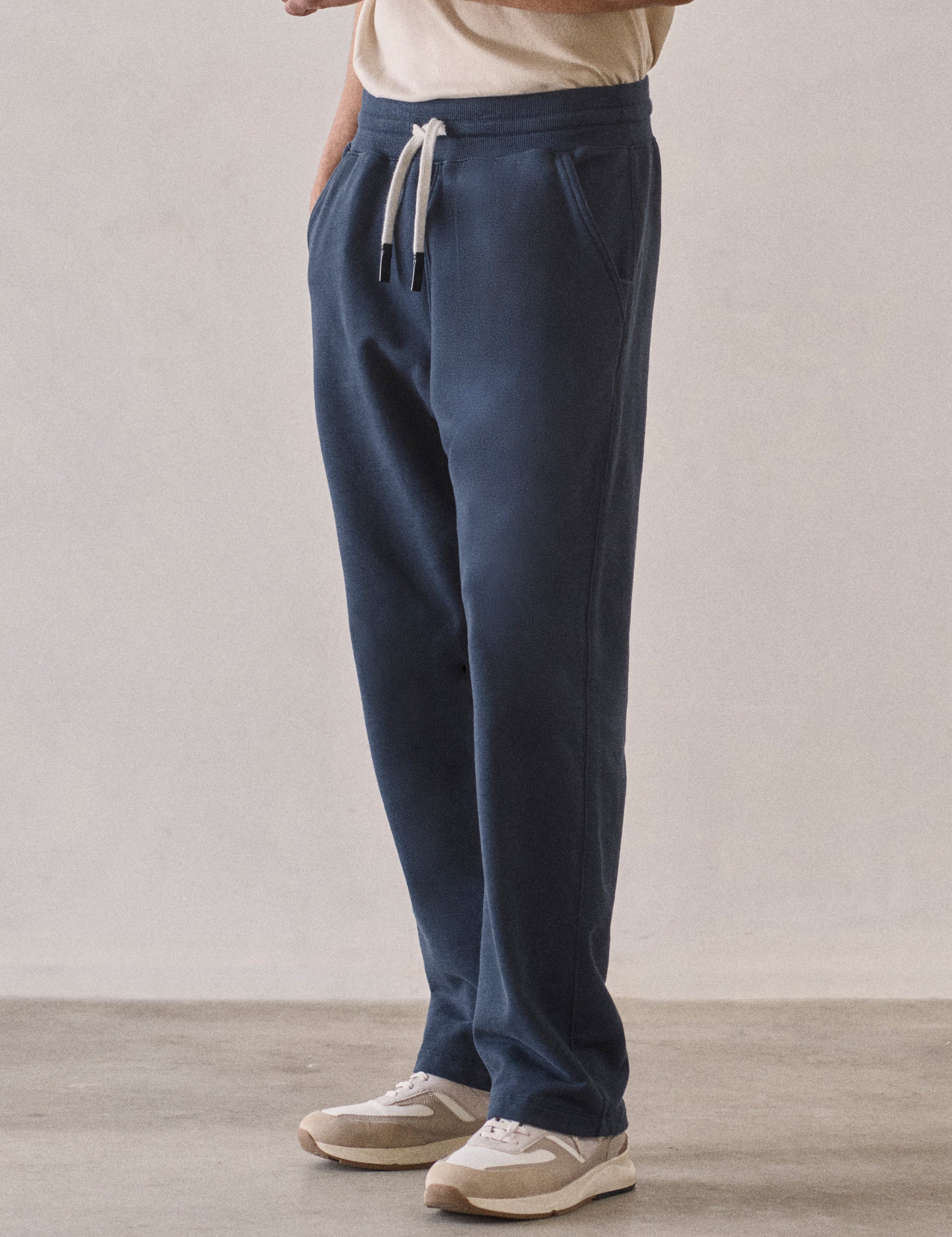 Front 3/4 lower body view of man wearing Osa Easy-Fit Sweatpant in Total Eclipse dark blue from AETHER Apparel.