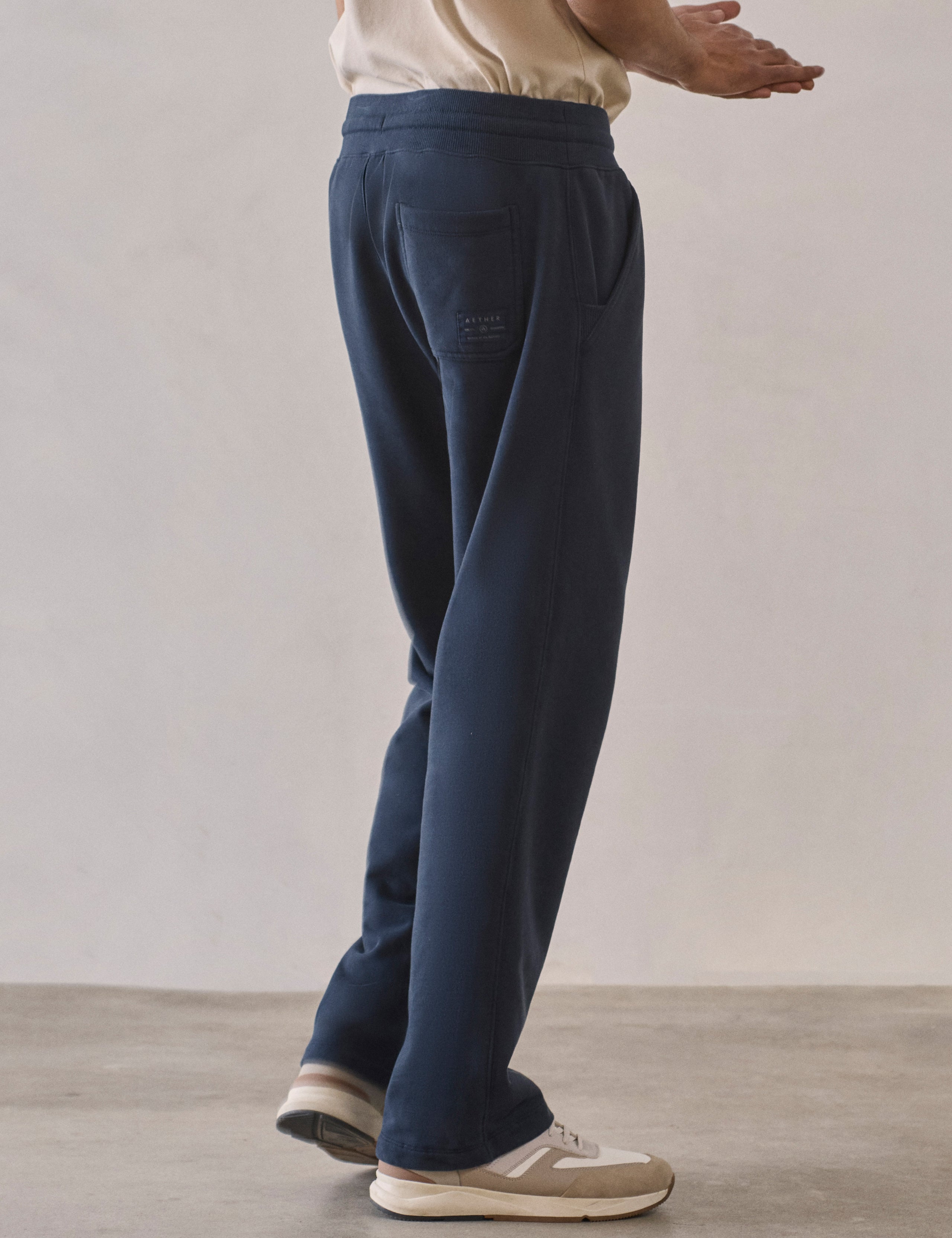 Rear 3/4 lower body view of man wearing Osa Easy-Fit Sweatpant in Total Eclipse dark blue from AETHER Apparel.