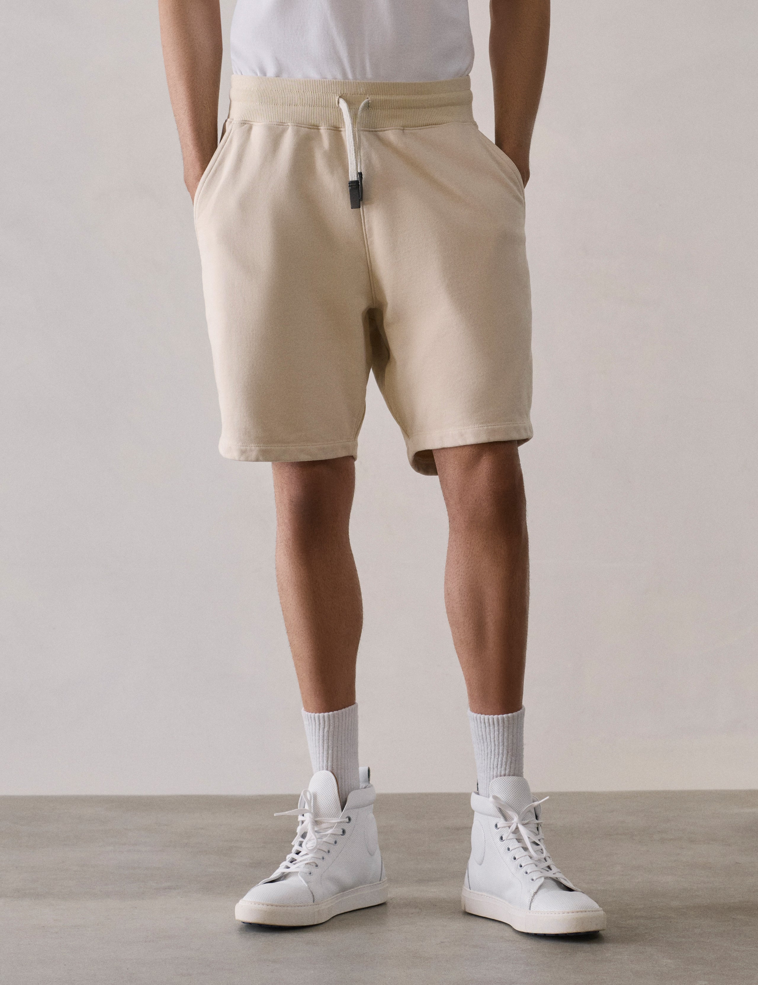 Front lower body view of man wearing Osa Sweatshort in Bone white from AETHER Apparel.