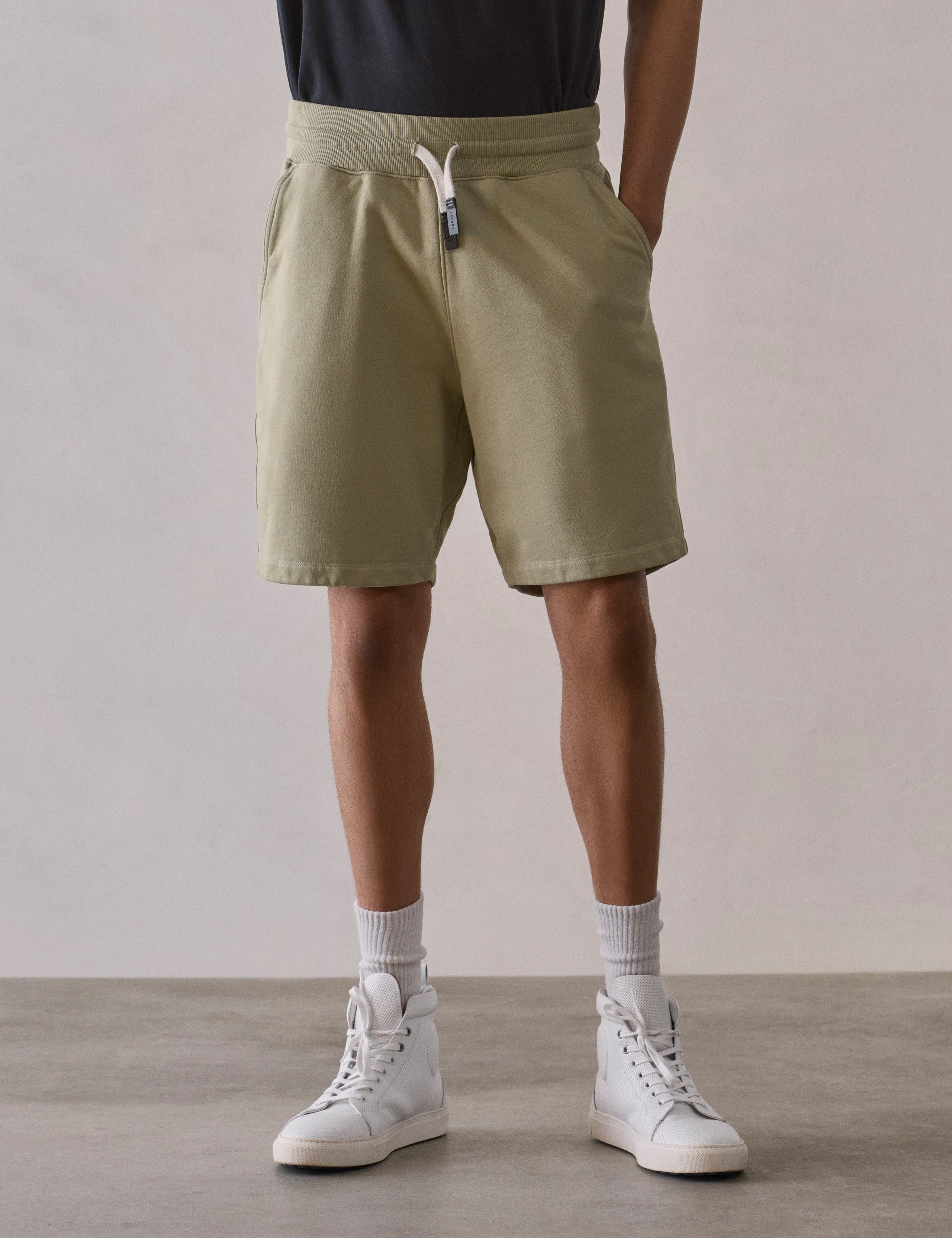 Front lower body view of man wearing Osa Sweatshort in Sage Green from AETHER Apparel.