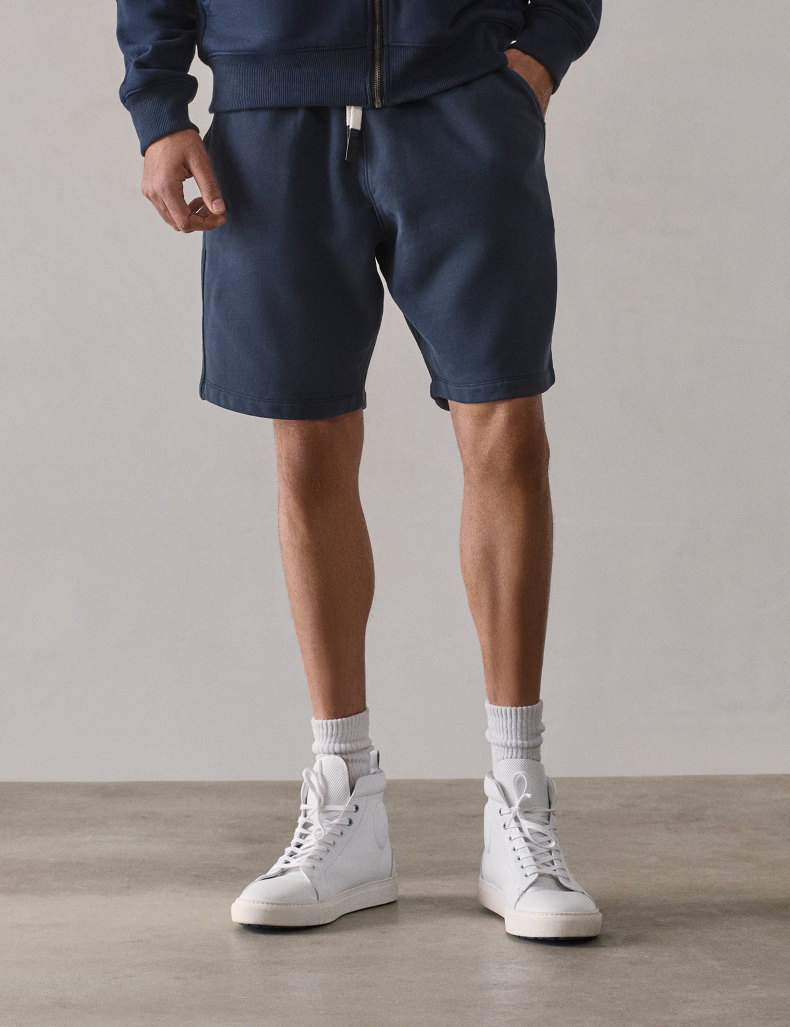 Front lower-body view of man wearing Osa Sweatshort in Total Eclipse dark blue from AETHER Apparel.