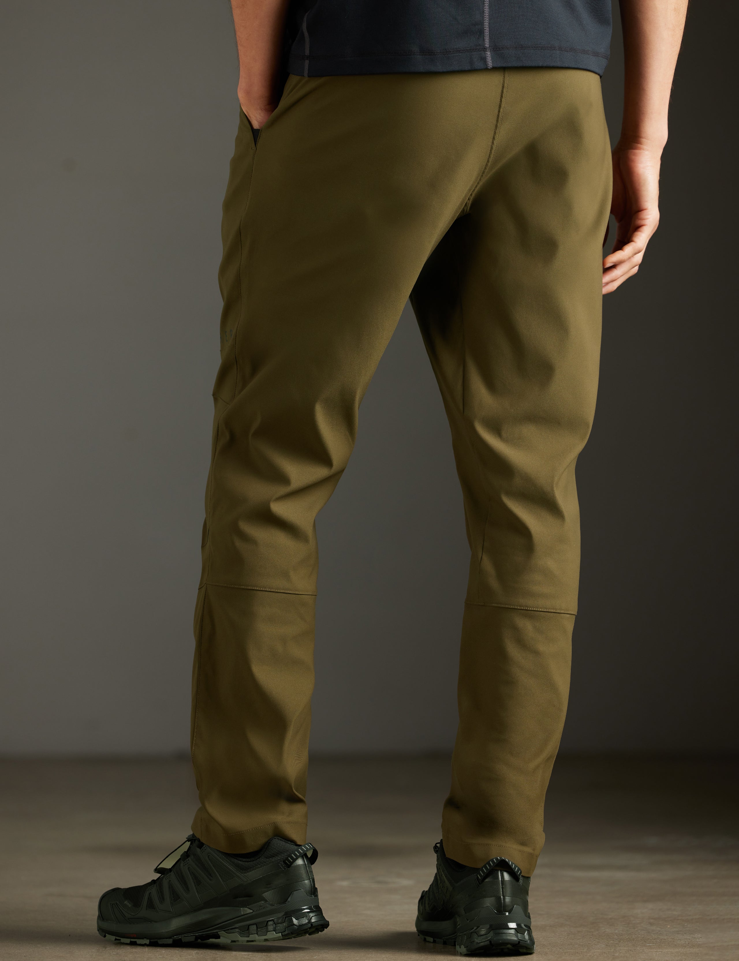Rear 3/4 lower body view of man wearing Perth Pant in Cadet Green from AETHER Apparel.