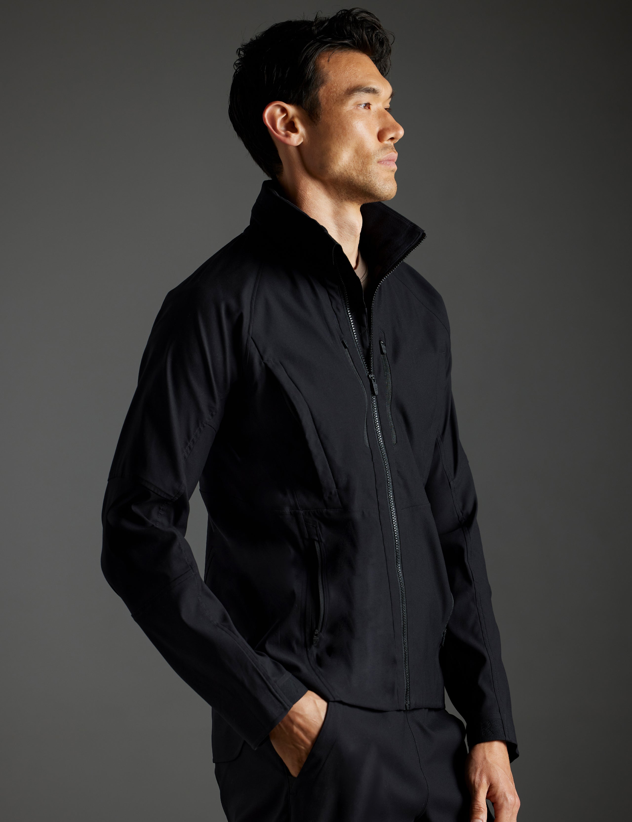 Side profile body view of man wearing Perth Vented Jacket in Onyx Black from AETHER Apparel.