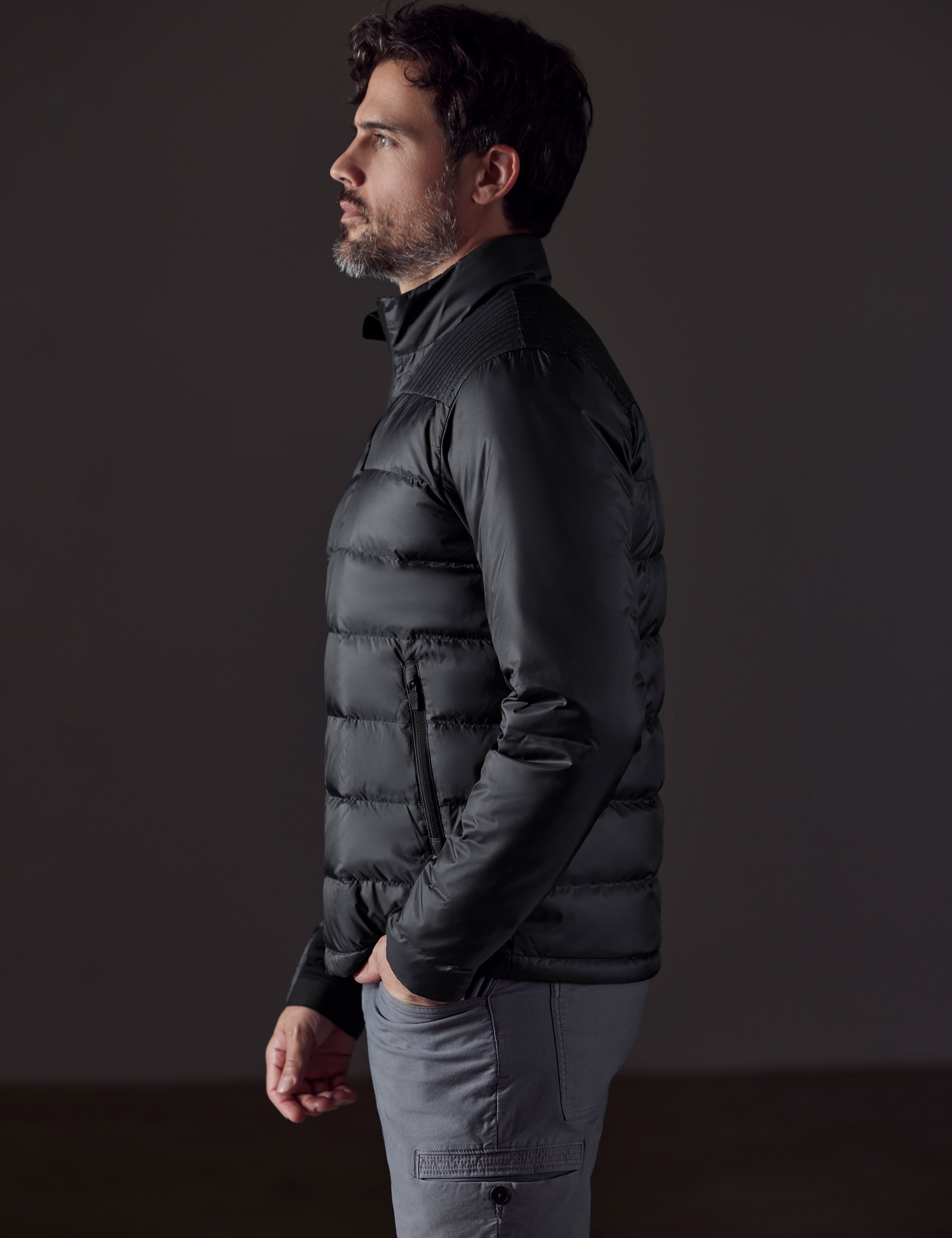 Side profile body view of man wearing Phantom Jacket in Onyx Black from AETHER Apparel.