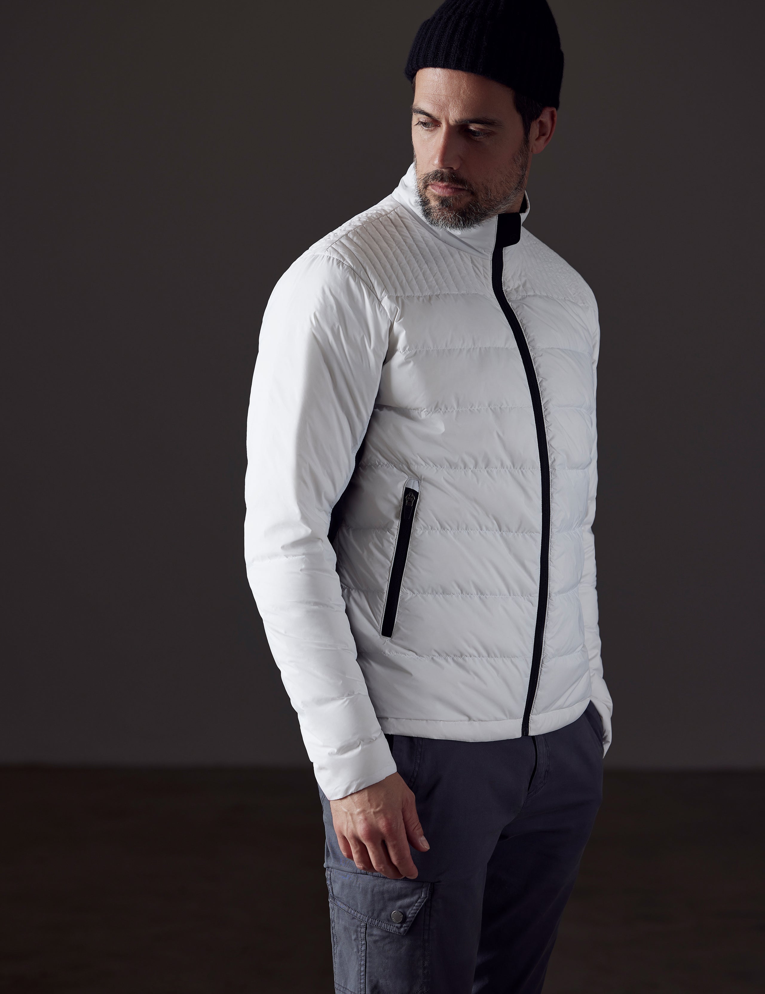 Front 3/4 body view of man looking over shoulder wearing Phantom Jacket in White from AETHER Apparel.
