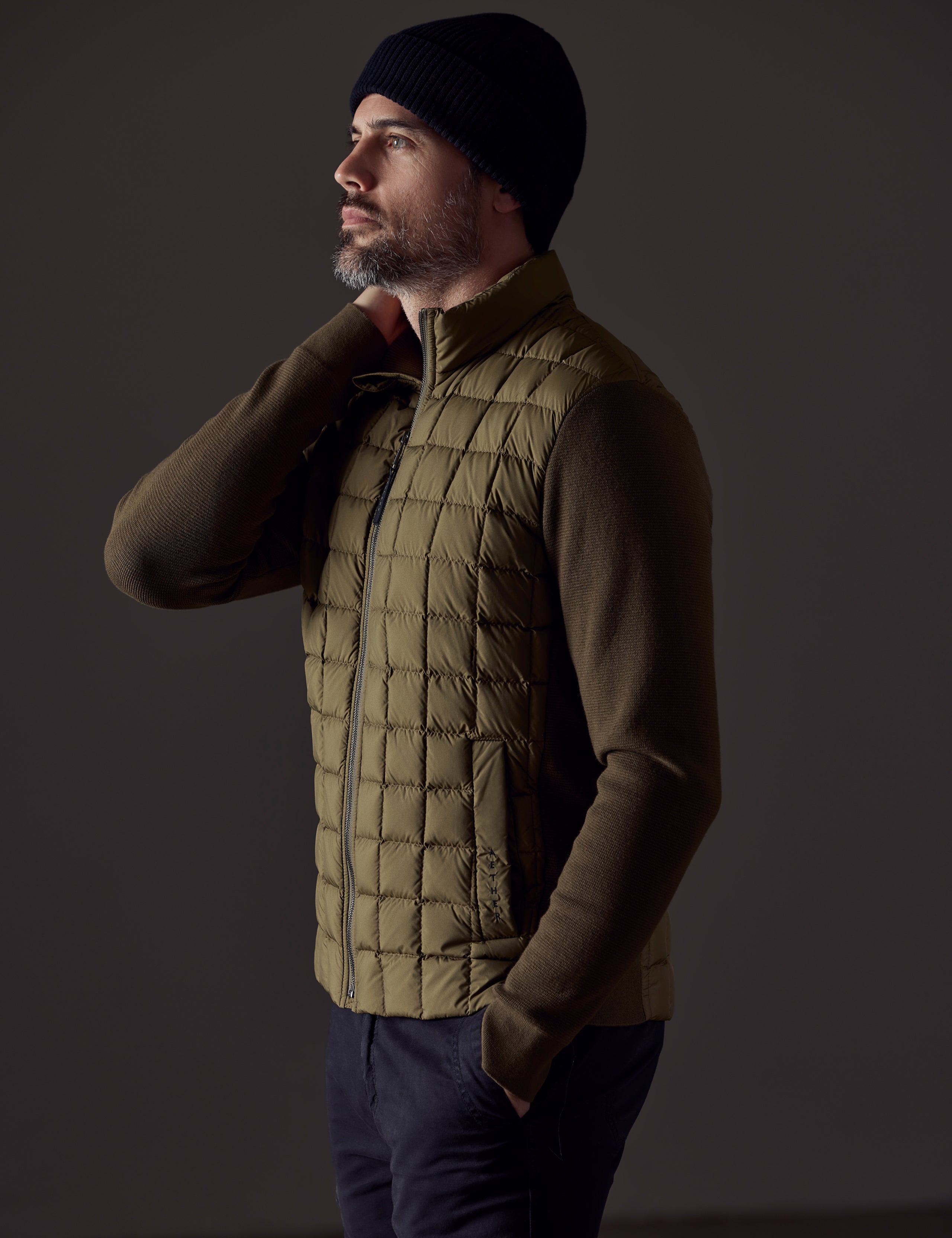Side profile body view of man wearing Phase Full-Zip in Command Green from AETHER Apparel.