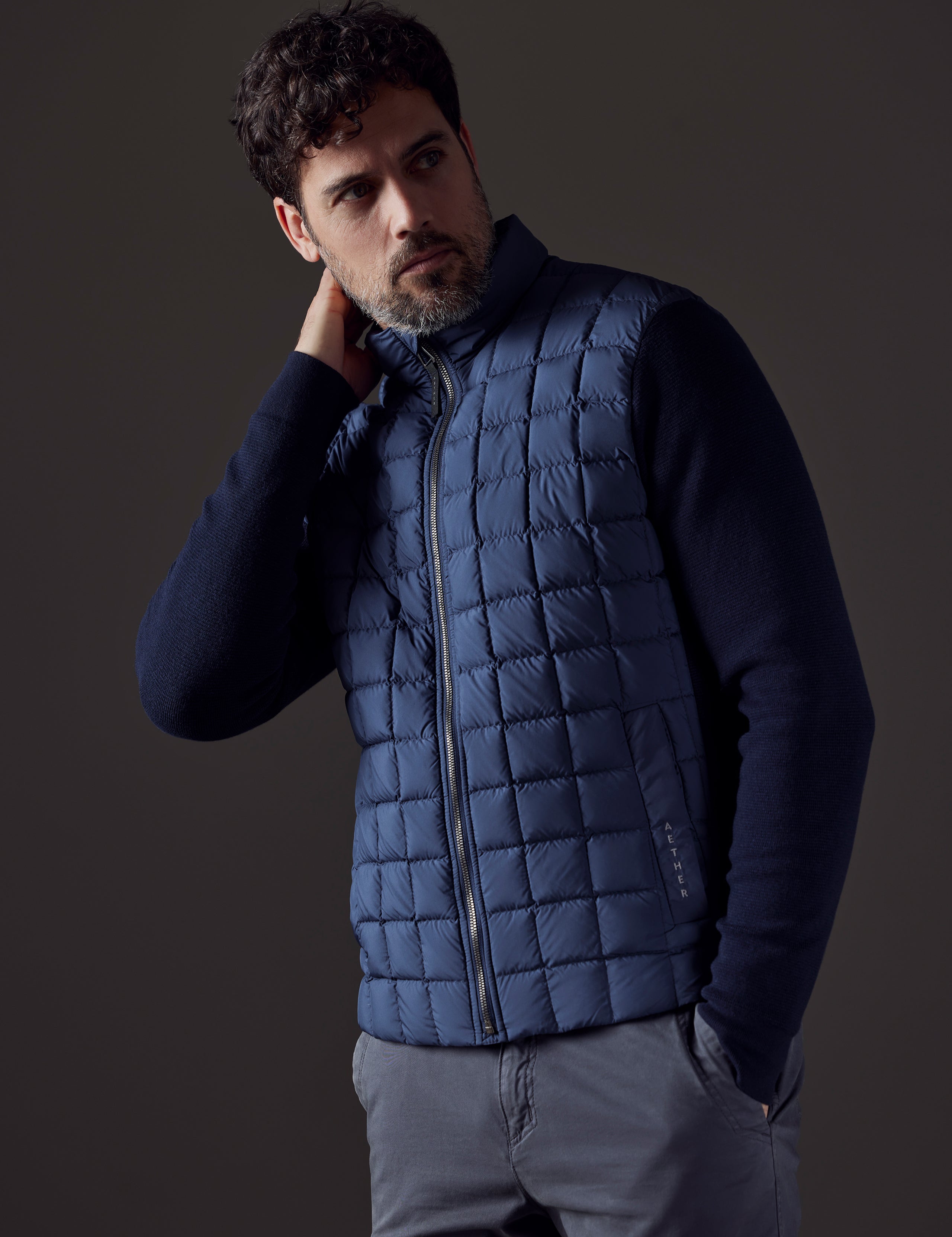 Front 3/4 body view of man wearing Phase Full-Zip in Total Eclipse dark blue from AETHER Apparel.