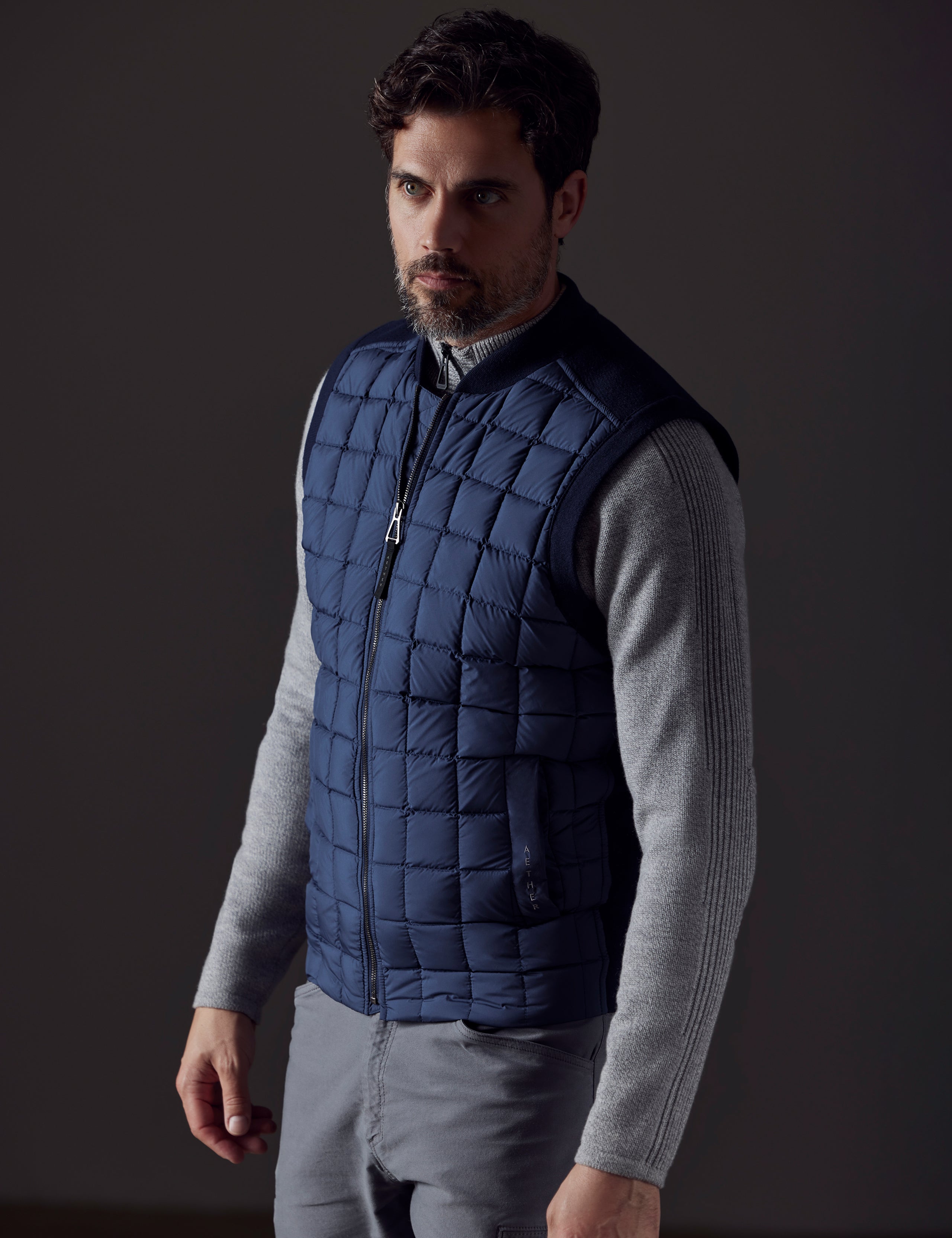 Front 3/4 body view of man wearing Phase Vest in Total Eclipse dark blue from AETHER Apparel.