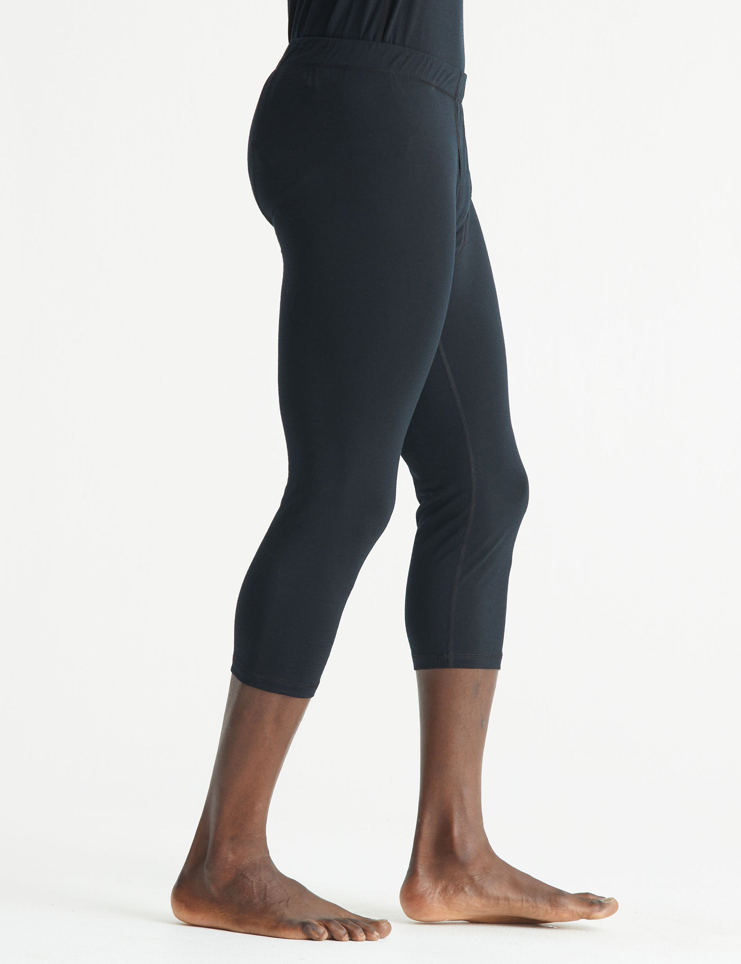 Side profile lower body view of man wearing Premium Merino Base Layer 3/4 Pant in Jet Black from AETHER Apparel.