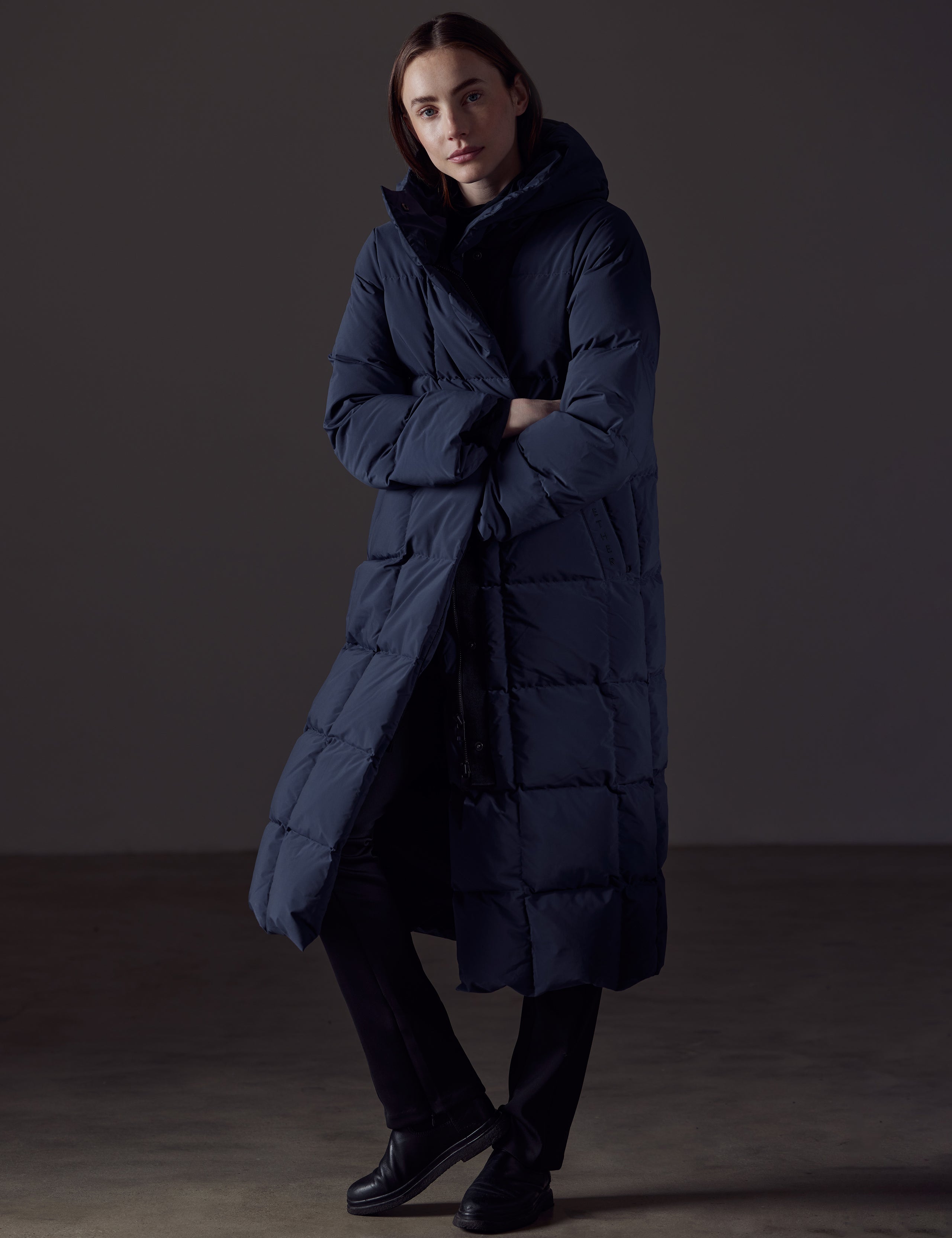 Front angled full-body view of woman wearing Shaw Jacket in Nordic Navy Blue from AETHER Apparel.