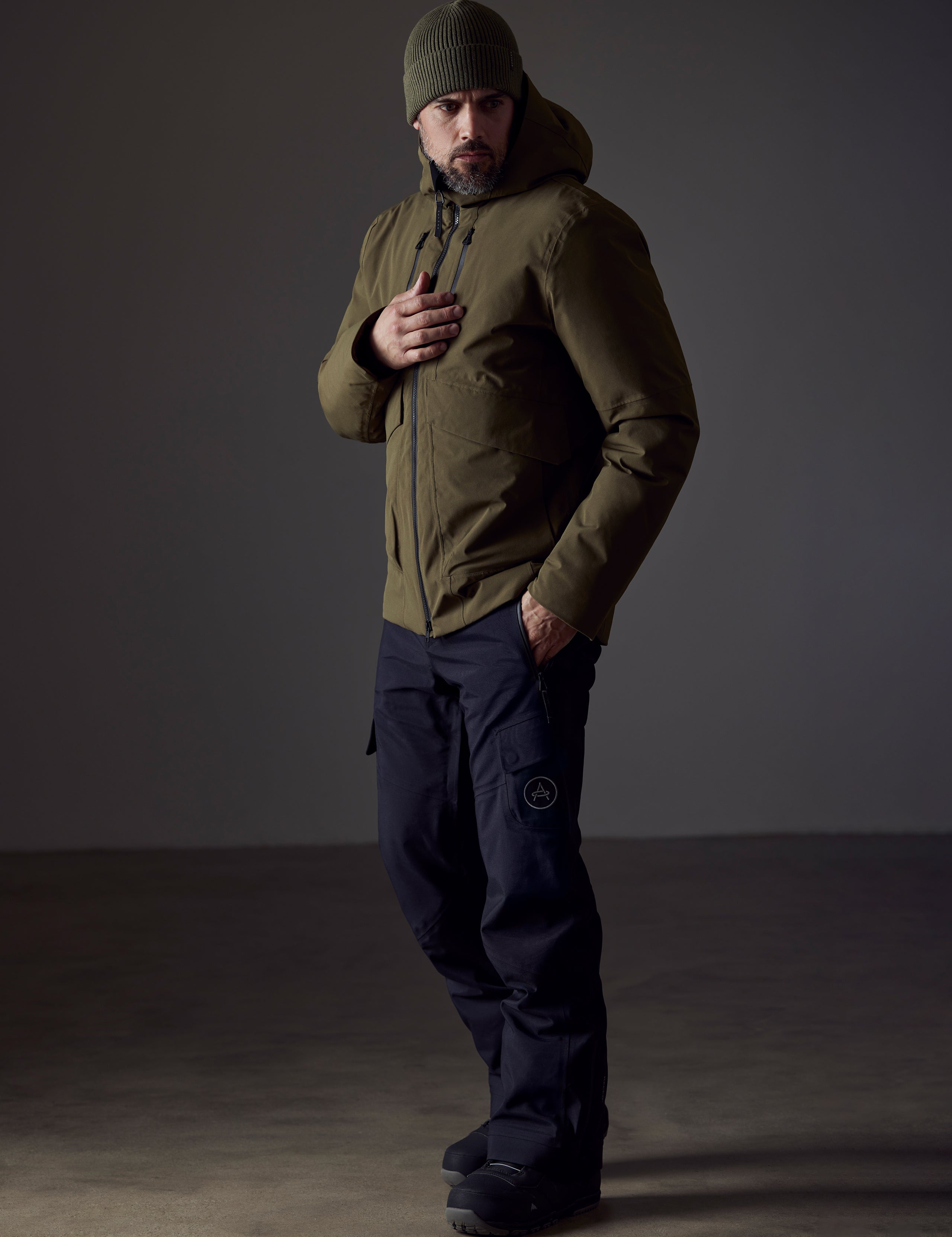 Front 3/4 full-body view of man wearing Silverton Down Jacket in Command Green from AETHER Apparel.