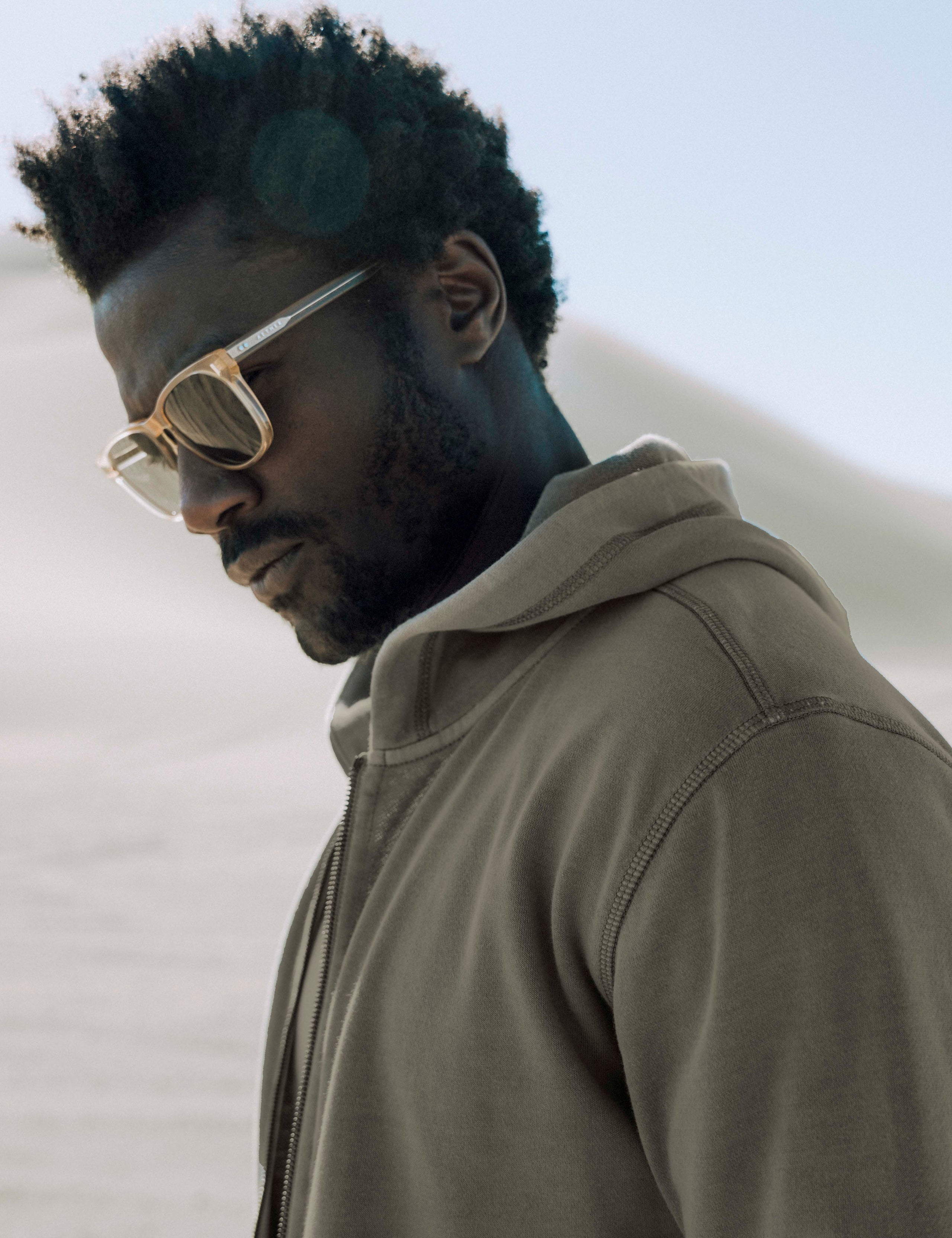 Outdoor lifestyle view of closeup of man wearing Solstice Lightweight Full-Zip Hoodie in Command Green from AETHER Apparel.