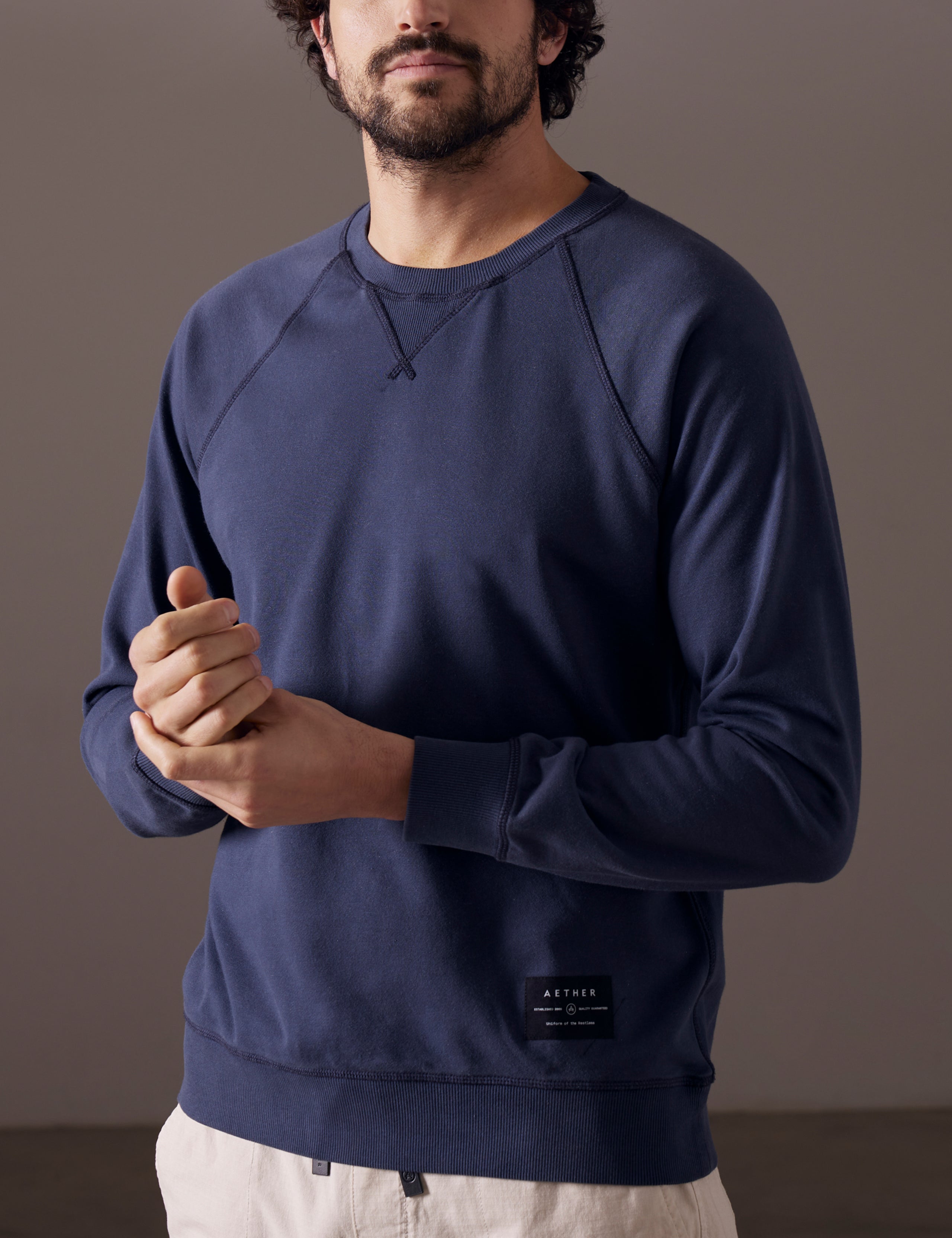 Front 3/4 body view of man wearing Solstice Lightweight Crew in Total Eclipse dark blue from AETHER Apparel.