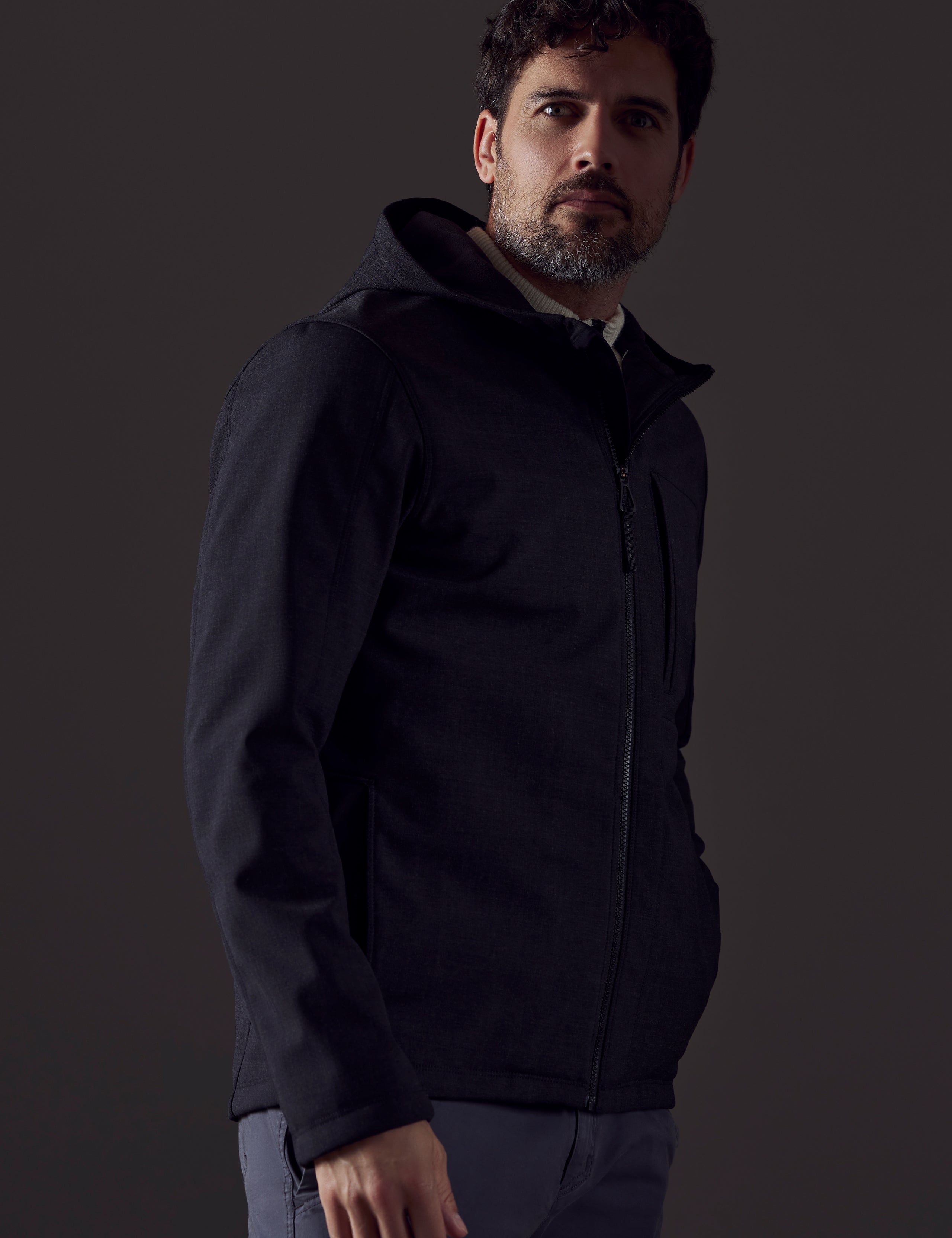 Side profile body view of man wearing Stanton Technical Jacket in Charcoal Heather from AETHER Apparel.