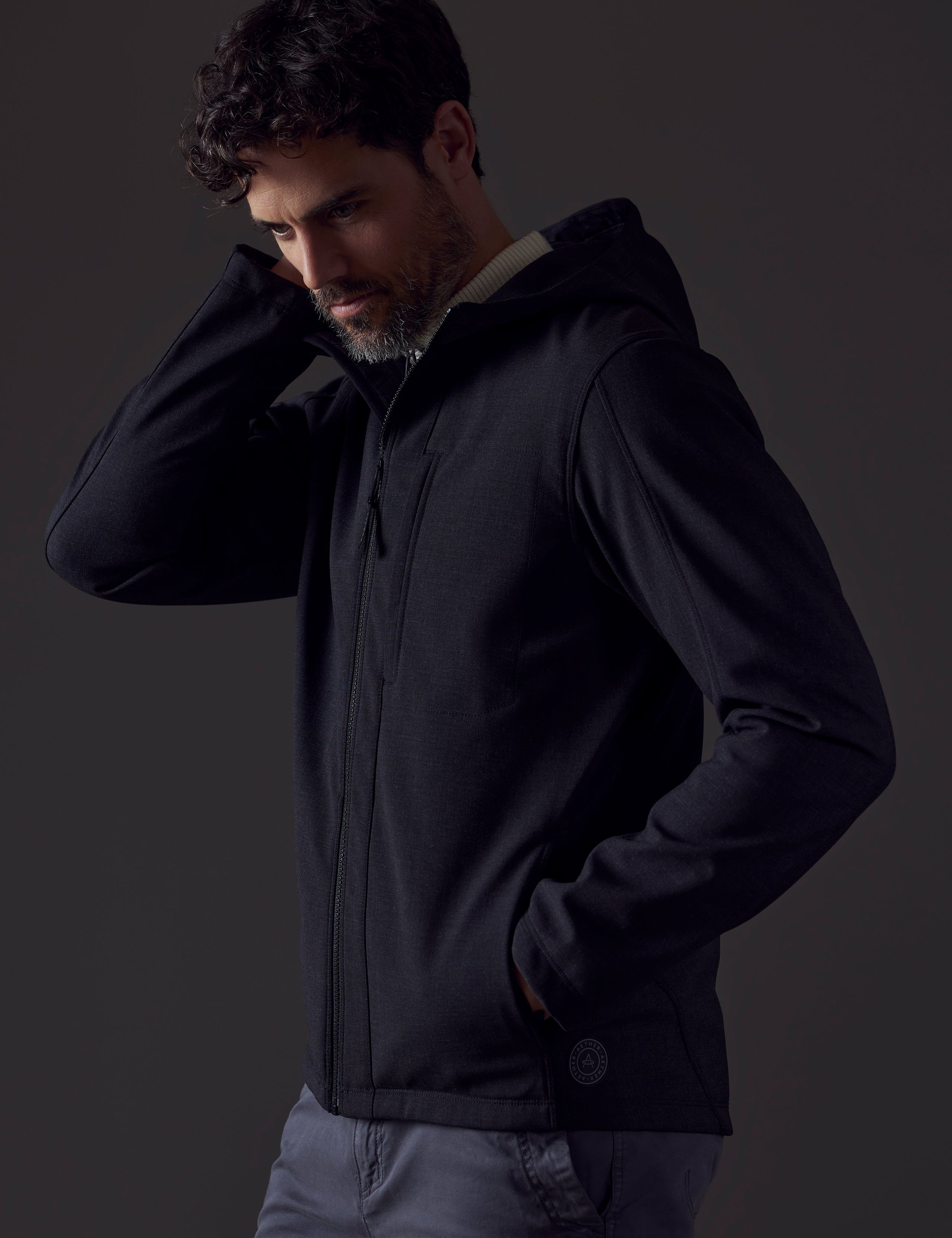 Front 3/4 body view of man wearing Stanton Technical Jacket in Charcoal Heather from AETHER Apparel.