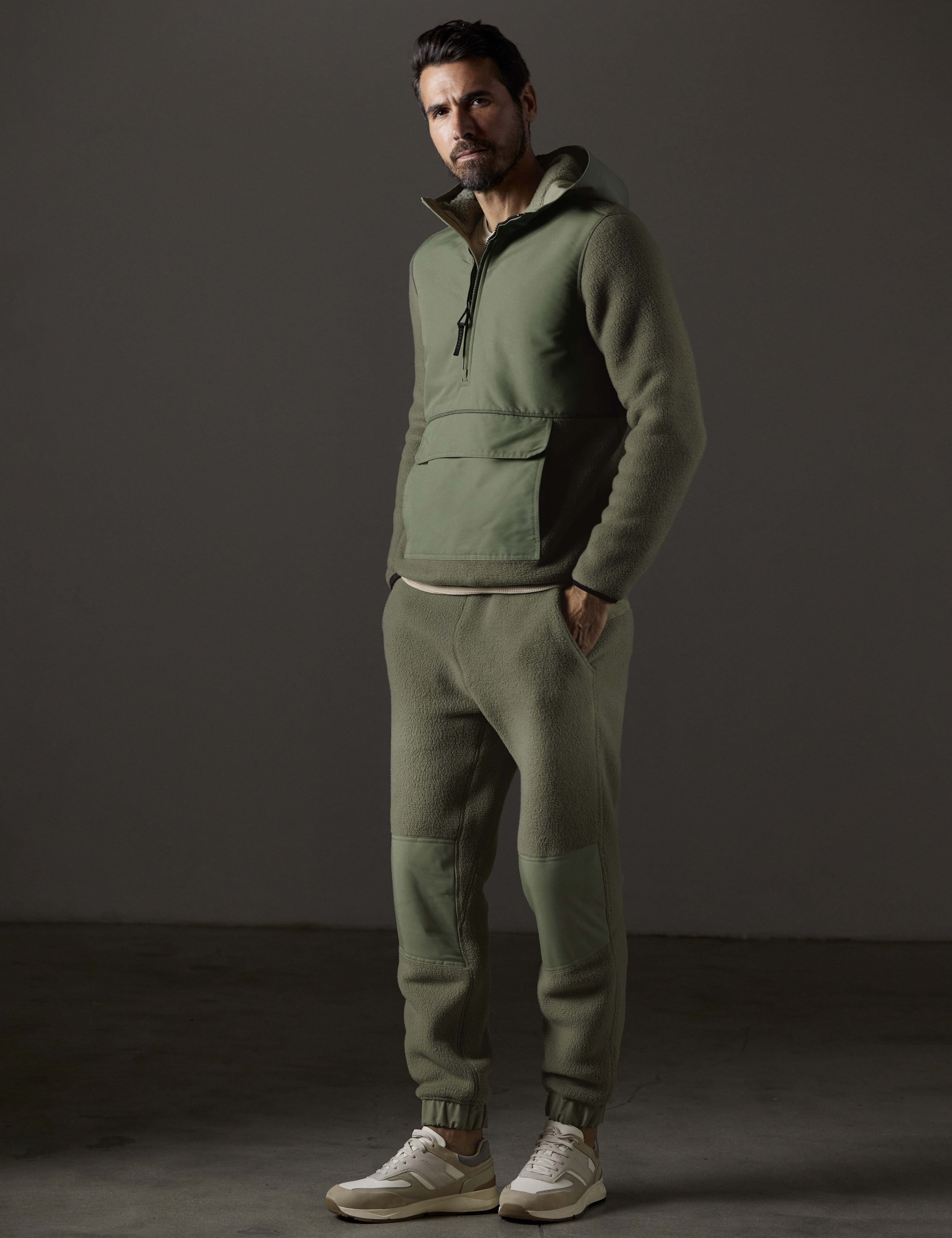 Front 3/4 full-body view of man wearing Walsh Hooded Anorak and Walsh Pant in Fern Green from AETHER Apparel.