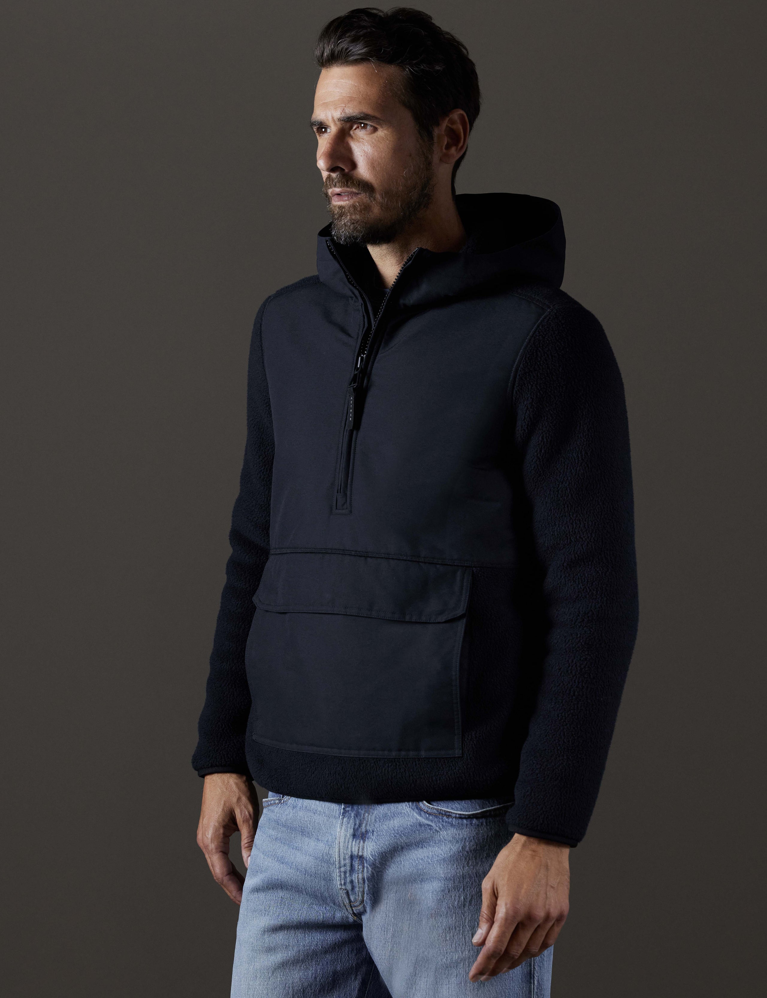 Front 3/4 body view of man wearing Walsh Hooded Anorak in Onyx Black from AETHER Apparel.