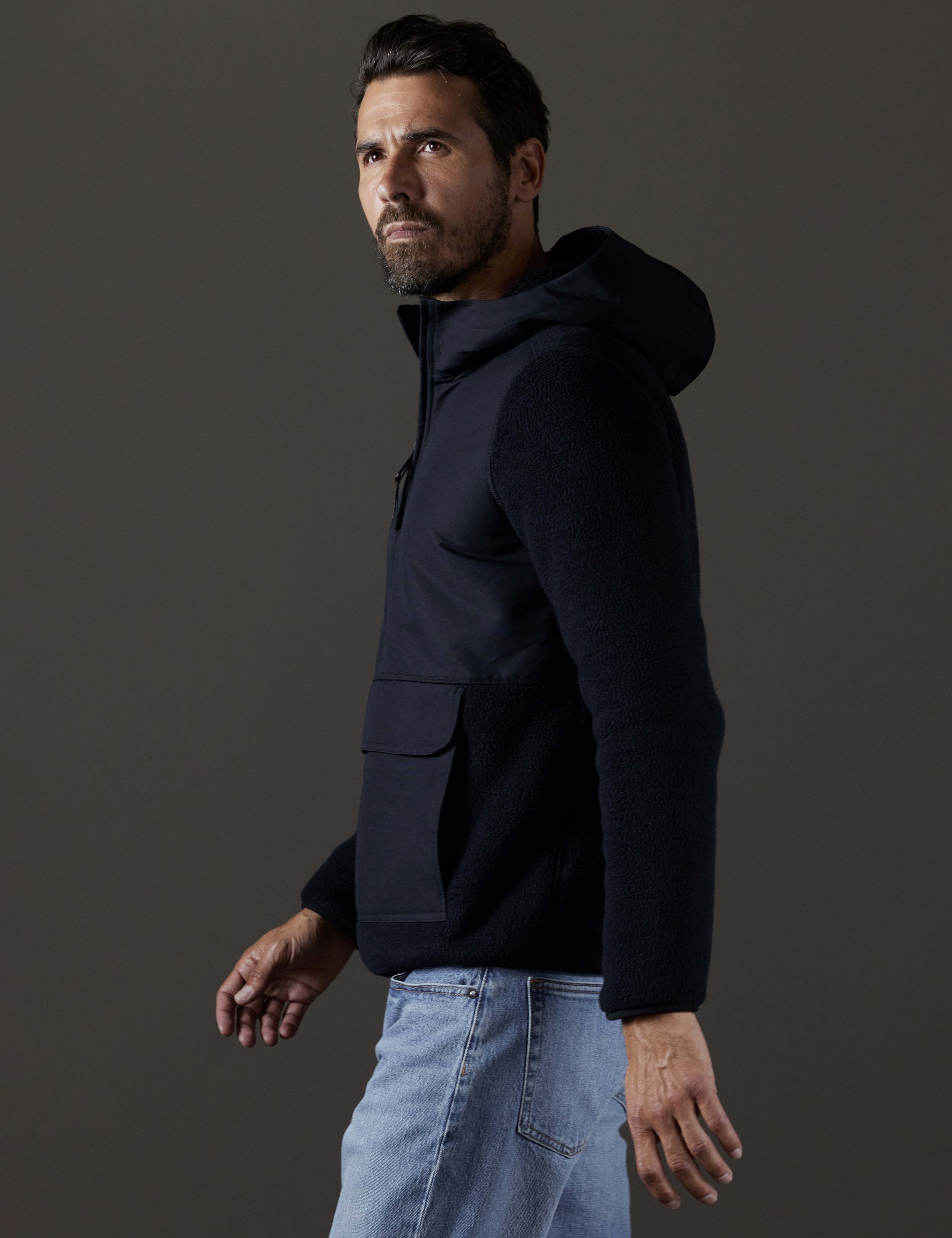 Side profile body view of man wearing Walsh Hooded Anorak in Onyx Black from AETHER Apparel.