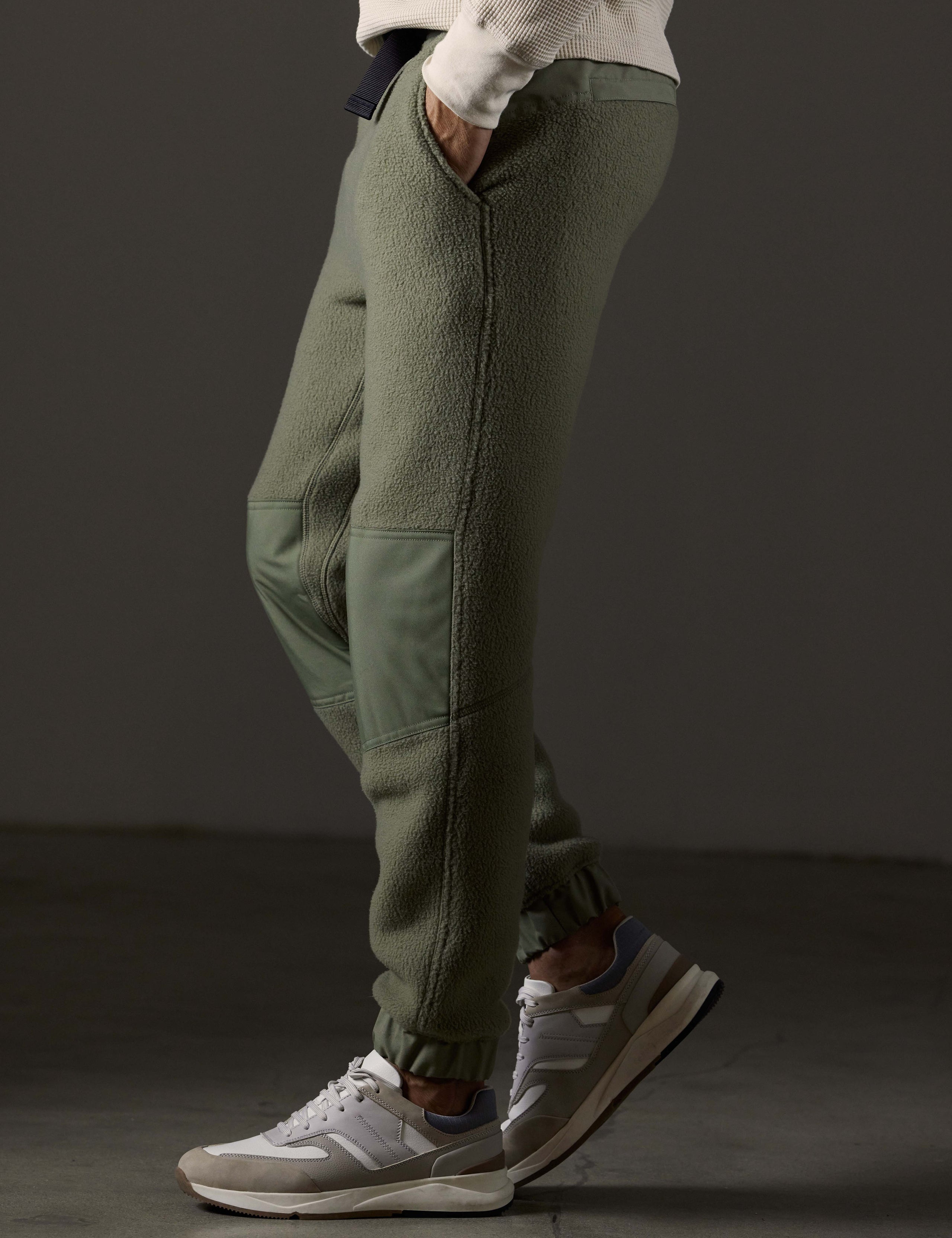 Side profile lower body view of man wearing Walsh Pant in Fern Green from AETHER Apparel.