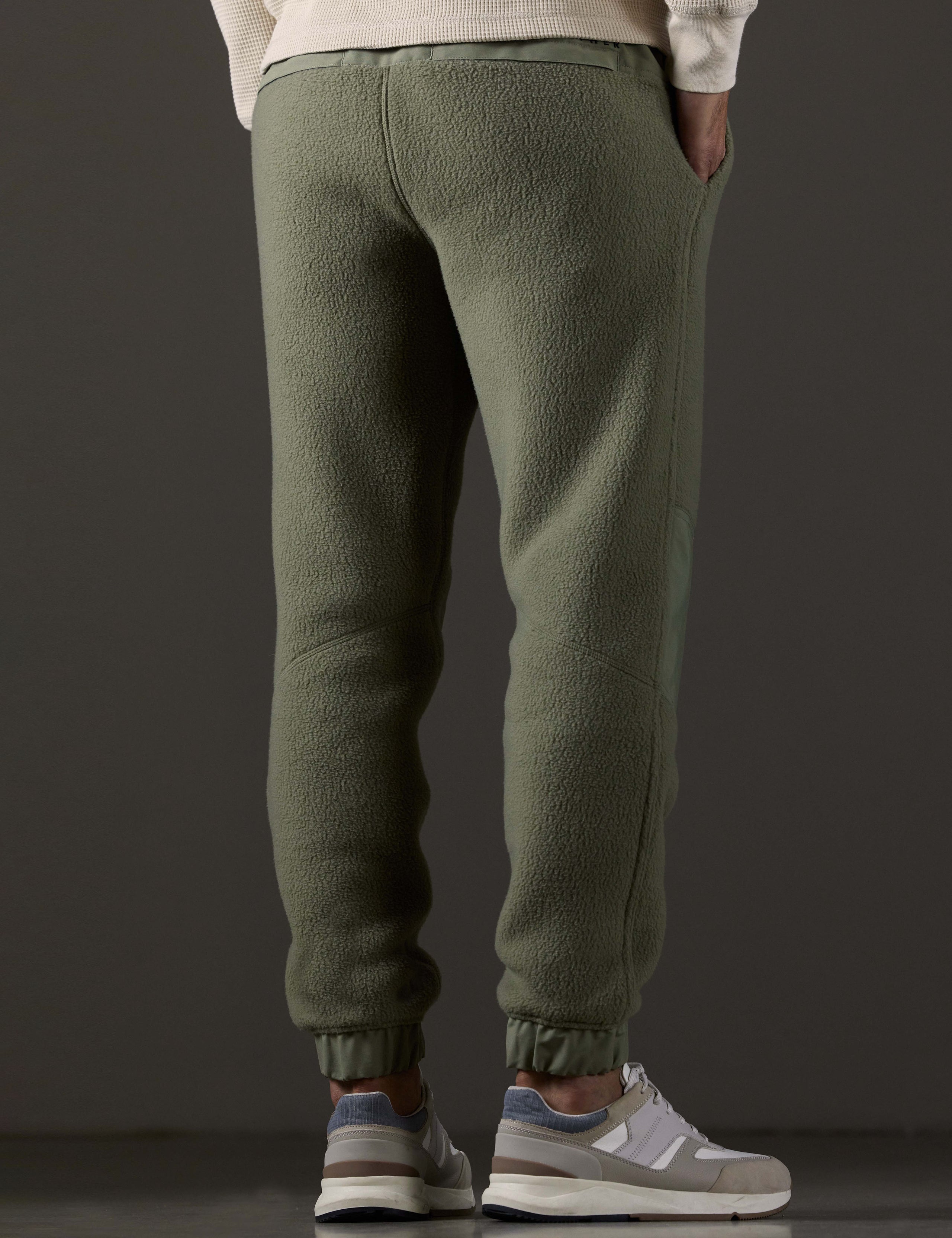 Rear 3/4 lower body view of man wearing Walsh Pant in Fern Green from AETHER Apparel.