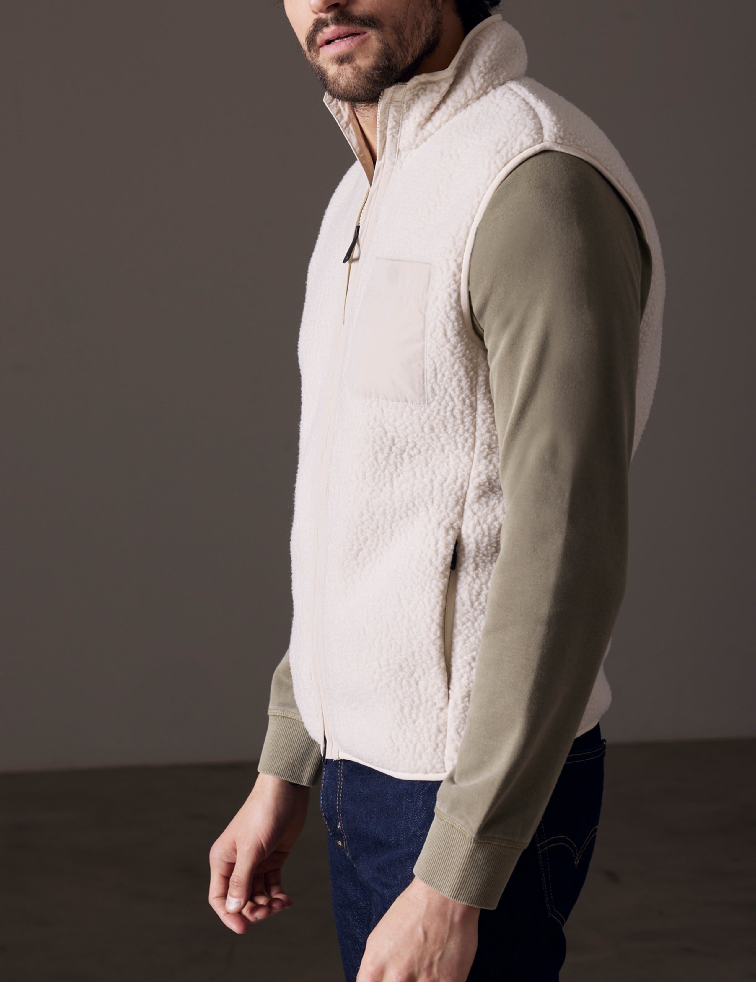 Side profile body view of man wearing Walsh Vest in Bone white from AETHER Apparel.