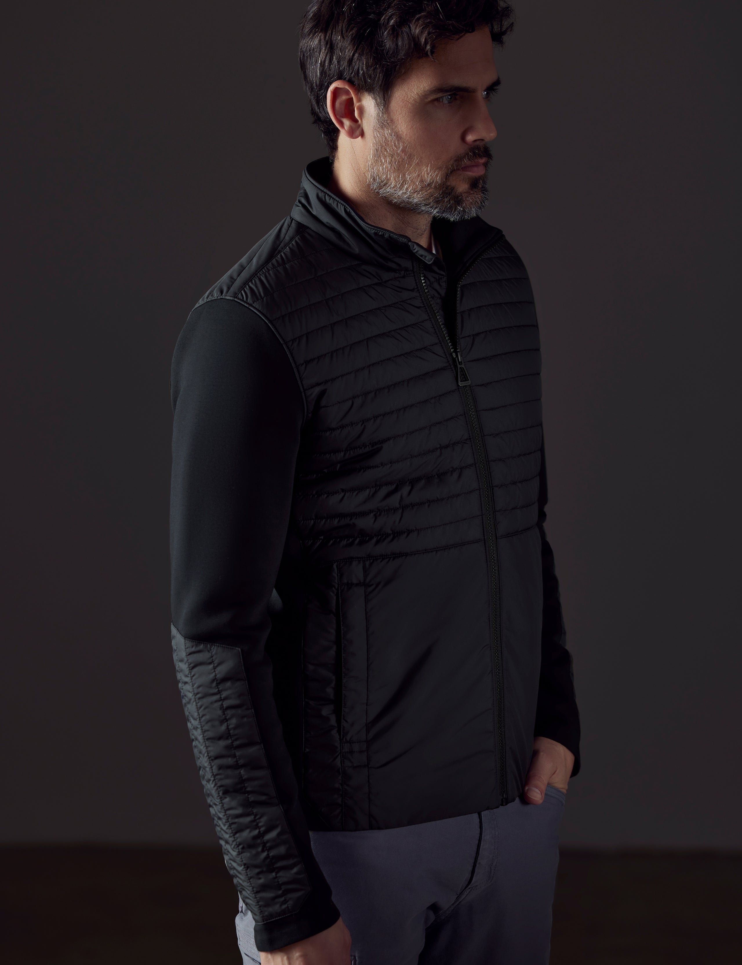 Front 3/4 body view of man wearing Watts Technical Jacket in Onyx Black from AETHER Apparel.