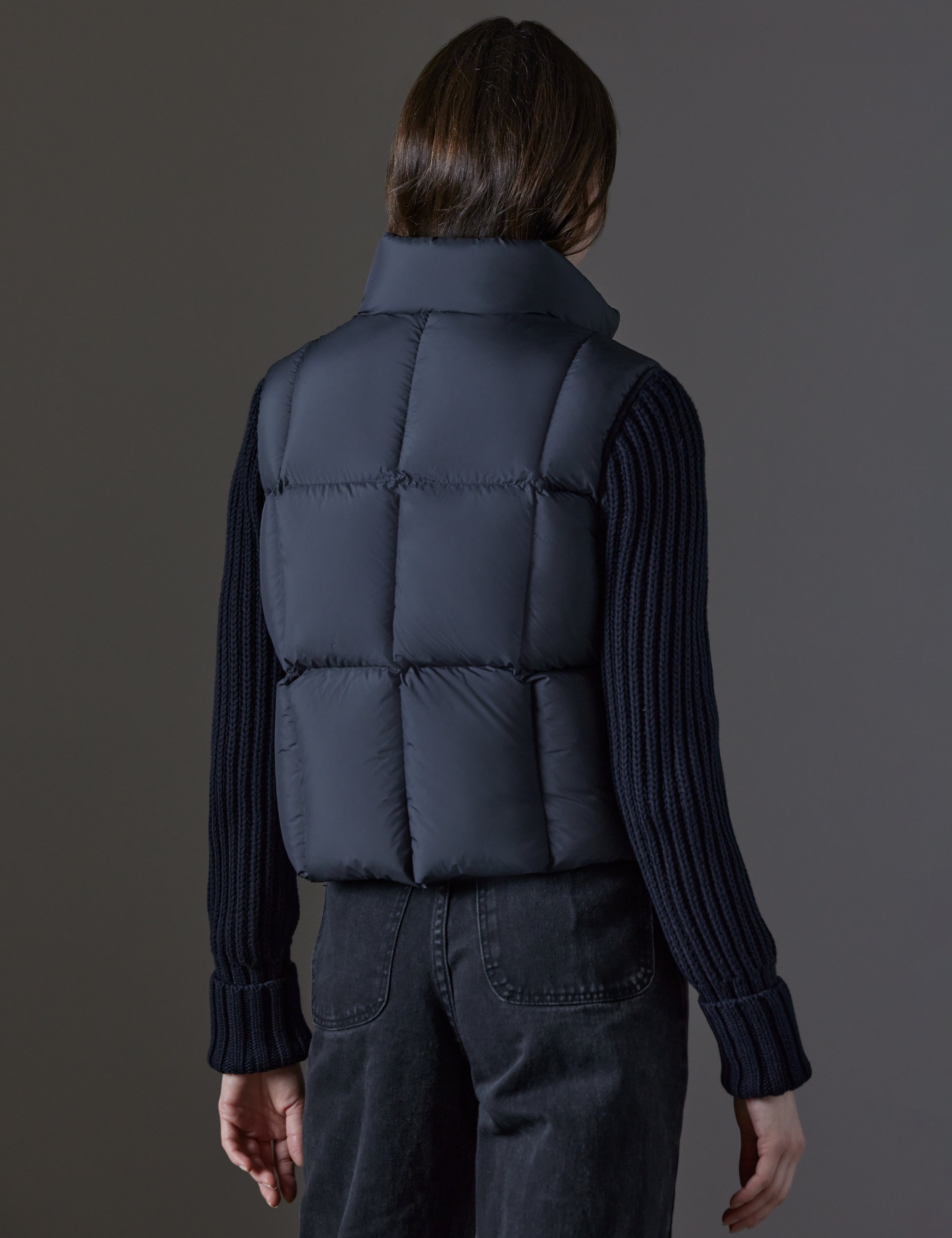 Rear angled view of woman wearing Nina Cardigan-Sleeve Jacket in Onyx Black from AETHER Apparel.