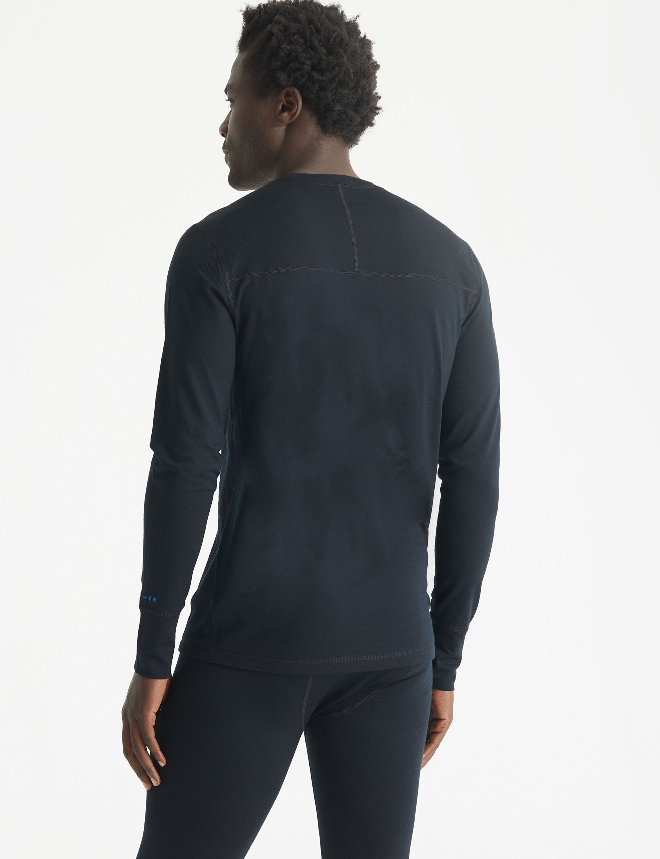 Rear 3/4 body view of man wearing Premium Merino Base Layer Crew in Jet Black from AETHER Apparel.