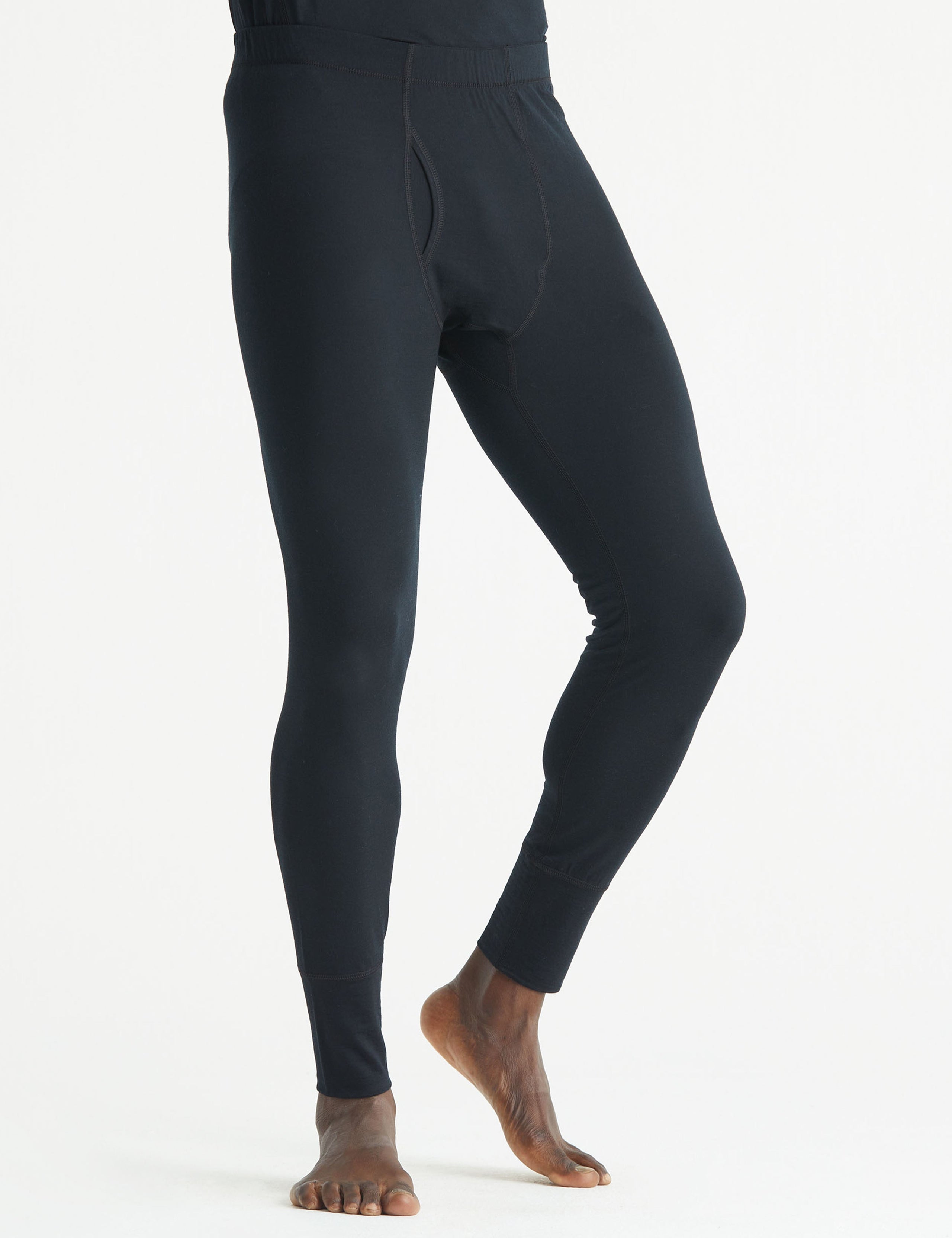 Front 3/4 lower body view of man wearing Premium Merino Base Layer Pant in Jet Black from AETHER Apparel.